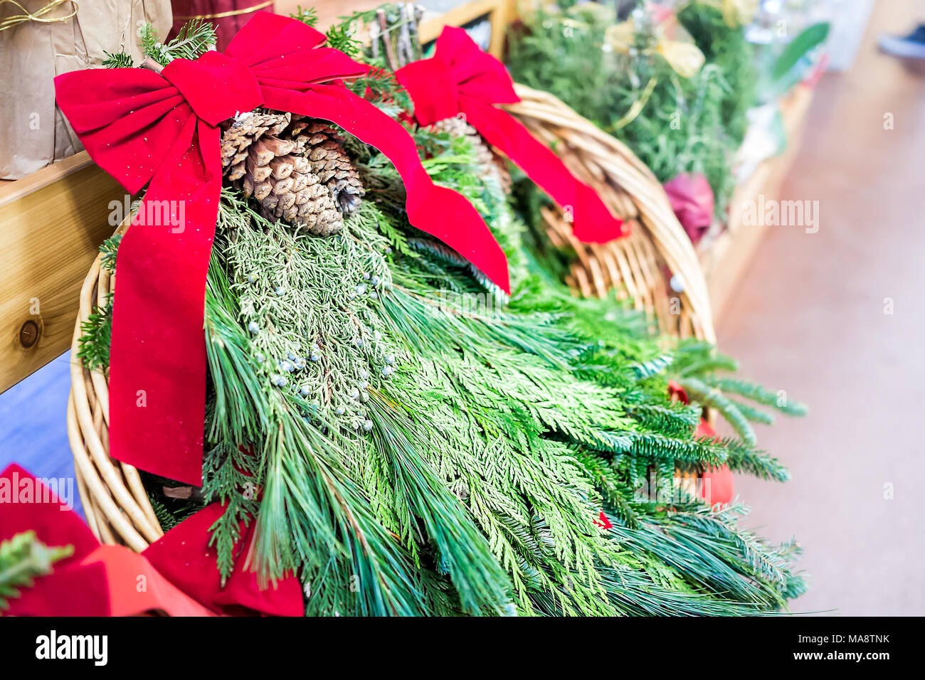 Green Pine needle red ribbon Mistel closeup im Korb auf dem Display in der Ferienzeit festliche Weihnachten store Shop, Wacholderbeeren, Tannenzapfen pinecon Stockfoto