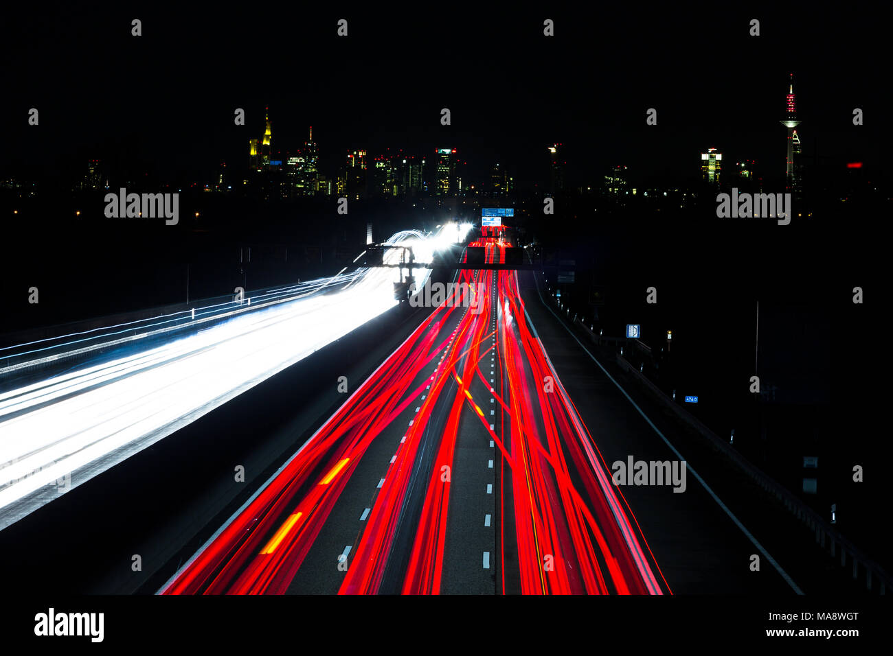 Nacht Verkehr Wanderwege auf einer deutschen Autobahn vor der Skyline von Frankfurt am Main - Deutschland, Bewegungsunschärfe Stockfoto