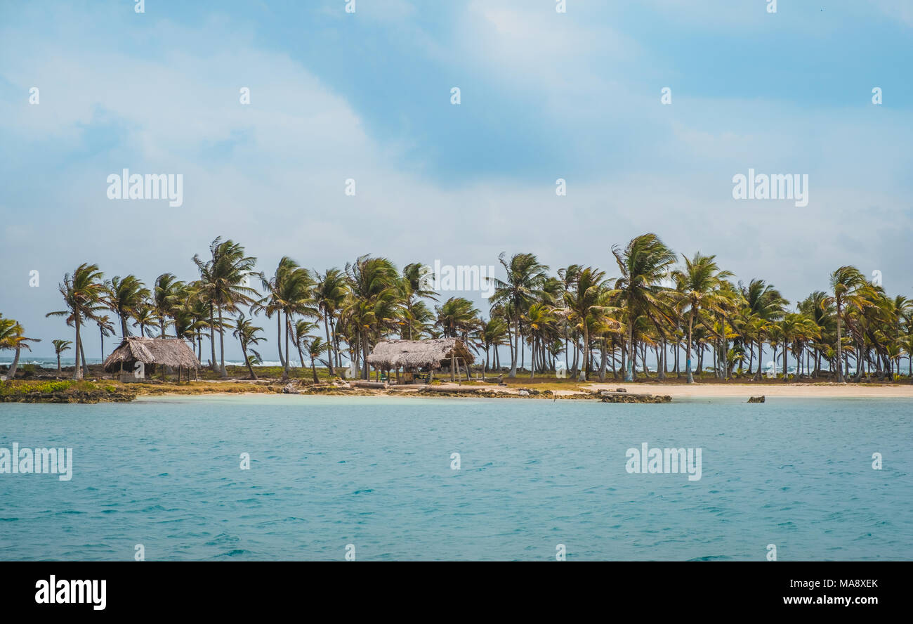 Wunderschöne Insel Strand mit Palmen und strohgedeckten Hütten an der Küste Stockfoto