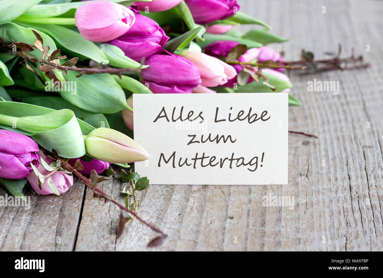 Grußkarte zum Muttertag mit rosa und violett Tulpen, im Herzen und im deutschen Text: Happy Mother's Day Stockfoto