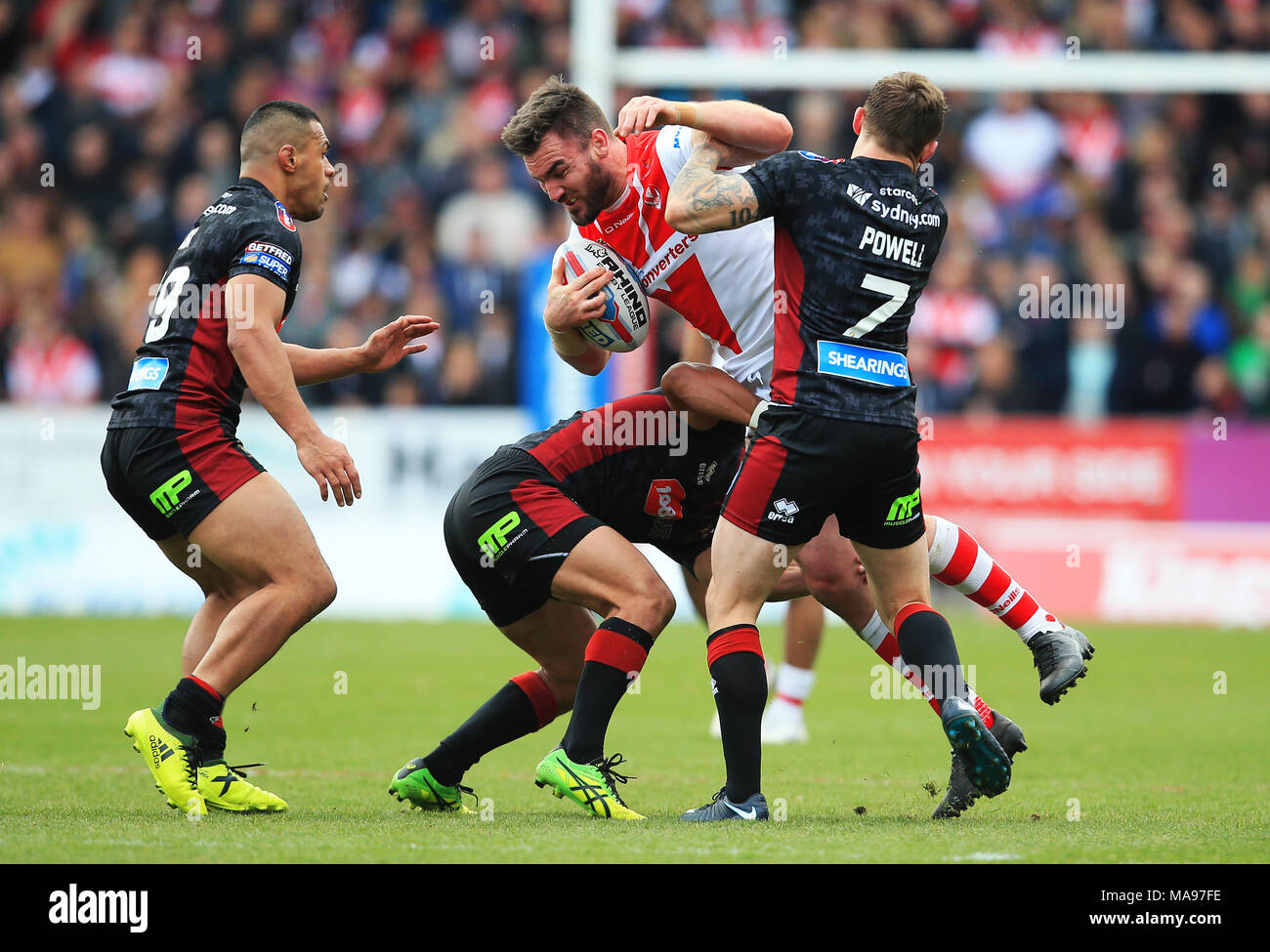 St. Helens' Lukas Douglas übernimmt Wigan Warriors' Sam Powell während der Super League Match an der völlig Gottlosen Stadion, St Helens. Stockfoto