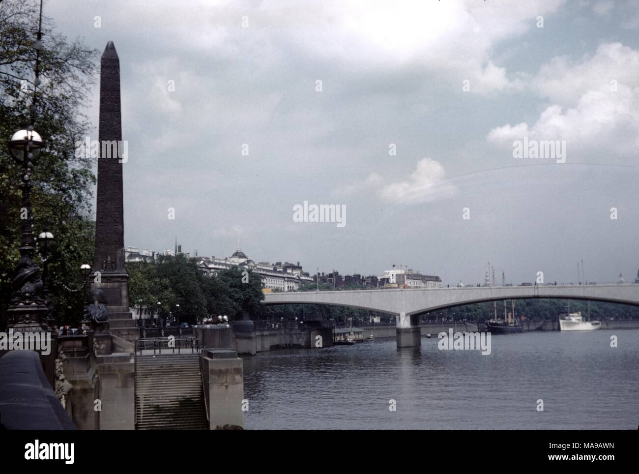 Blick auf die Innenstadt von London, England an einem bewölkten und bewölkten Tag, mit der Themse und Waterloo Bridge sichtbar und Cleopatra's Needle, ein ägyptischer Obelisk, im Vordergrund, 1955. () Stockfoto