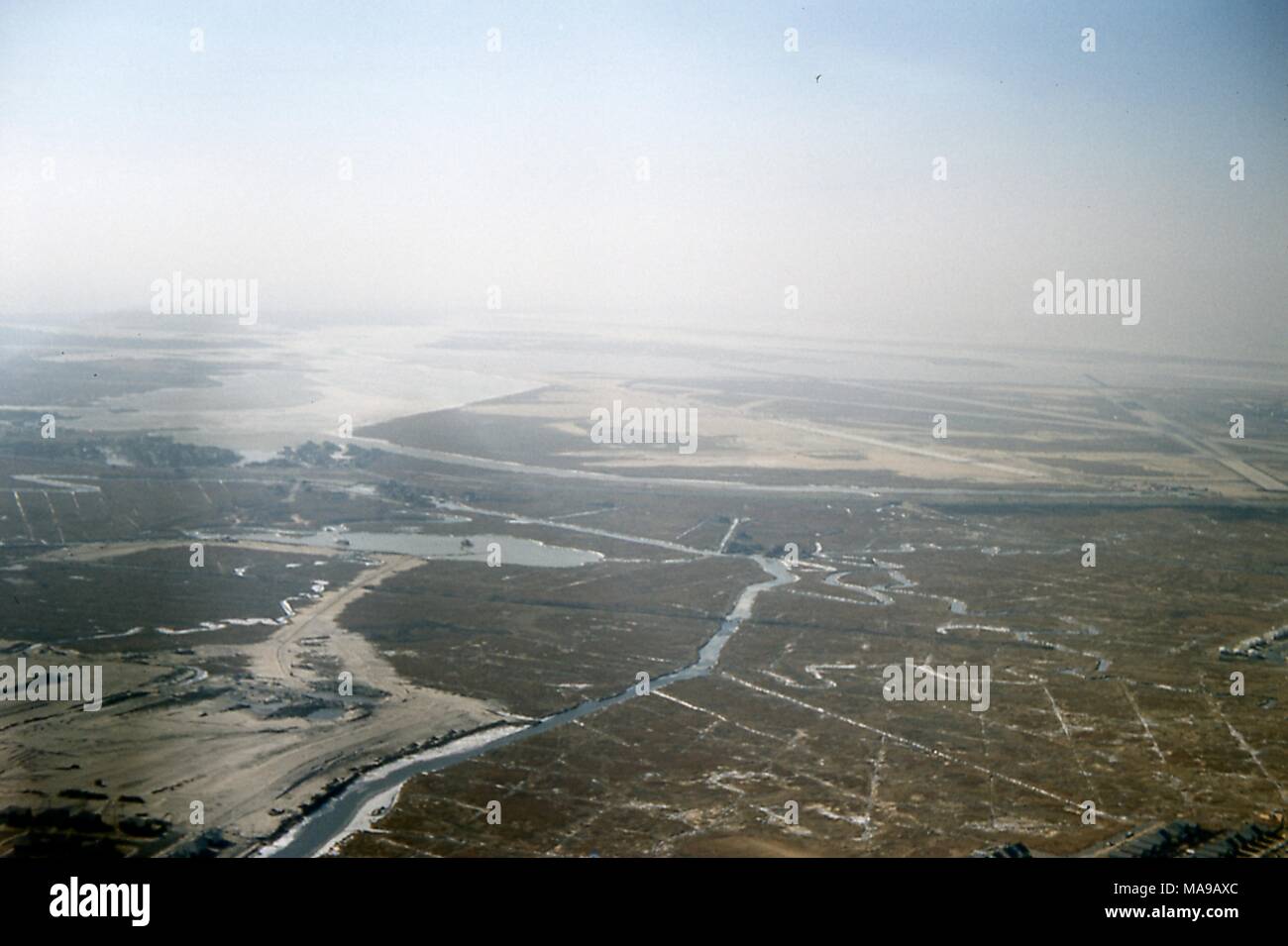 Luftbild mit Blick auf west-südwestlich der Nachbarschaften von Meadowmere, Haken Creek, Meyer Hafen, North Woodmere, Rosedale, Brookville, entlang der Grenze zwischen der Gemeinde von Queens, New York City, und Nassau County, Long Island, New York, März, 1959. Viele Häuser und Strukturen werden sichtbar entlang der Kanäle in den Sumpfgebieten an der linken Flanke zur Mitte. Reihen der Fläche Wohnungen sind bei extremen rechten Ecke gesehen, mit Blick auf den Haken Creek links unten. Die wasserstraße so diagonal durch das marschland vor dem Entleeren in die Jamaica Bay in der Ferne. Sie GESCHWUNGENE am mittleren Rahmen ist Thurston Becken, Bor Stockfoto