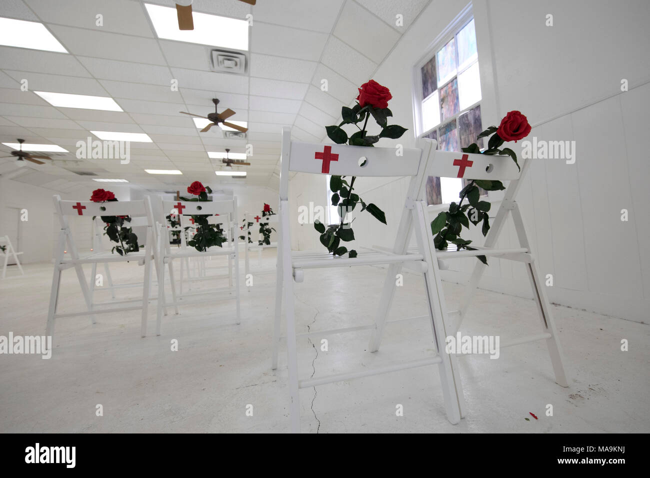 Innenraum der First Baptist Church von Sutherland Springs, TX, ist jetzt ein krasses Mahnmal für die 26 Gemeindemitglieder während der Dienst im November 2017 geschossen, mit einem weißen Stuhl und rote Rose zum Gedenken an die Opfer. Stockfoto