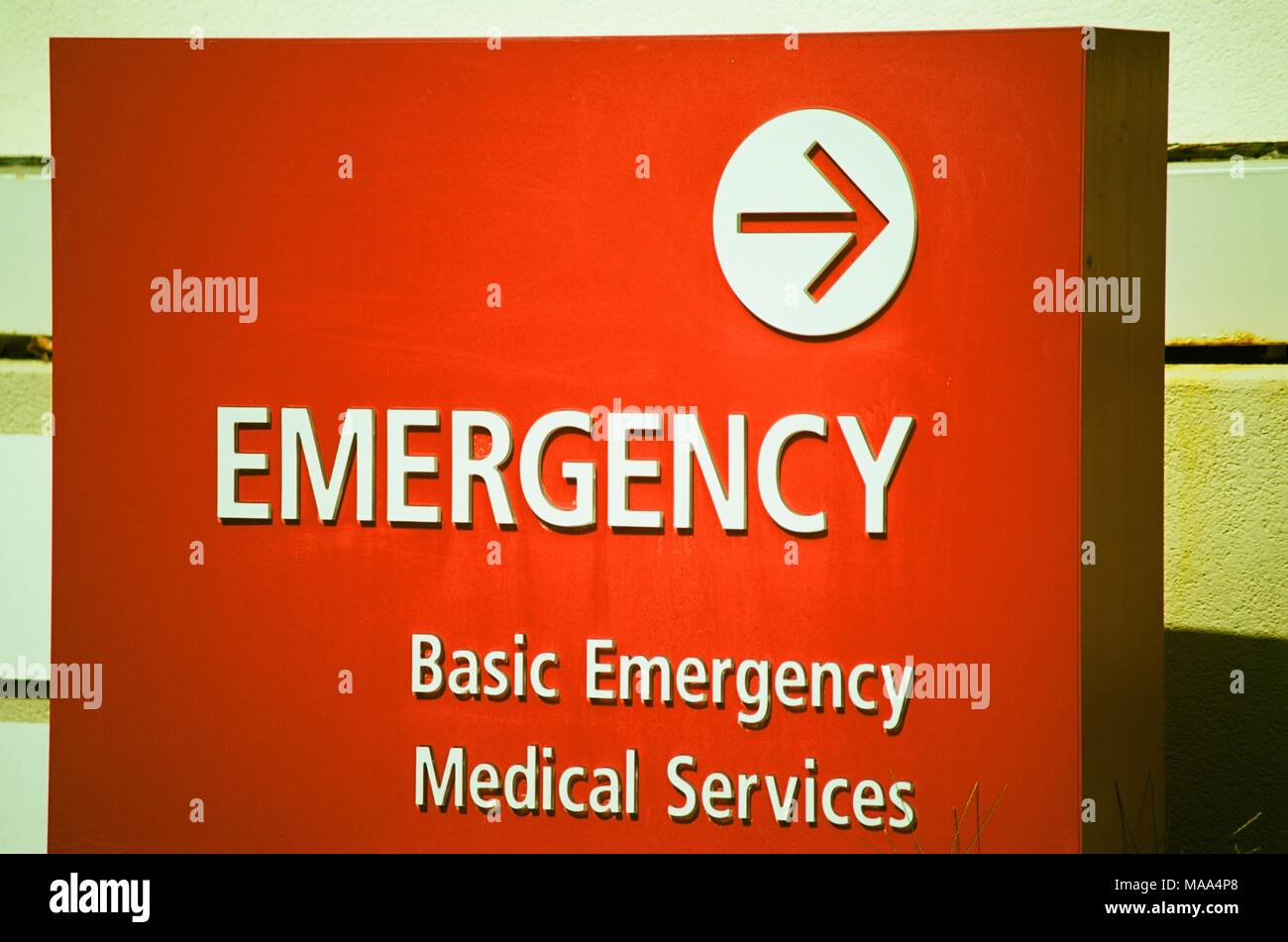 In der Nähe von hellen roten Schild zur Lage von der Notaufnahme, mit dem Text "Notfall" in großen Buchstaben und die Zeile 'Basic Emergency Medical Services", was darauf hinweist, dass die Fazilität stellt die Notfallmedizin, Concord, Kalifornien, 8. September 2017. () Stockfoto