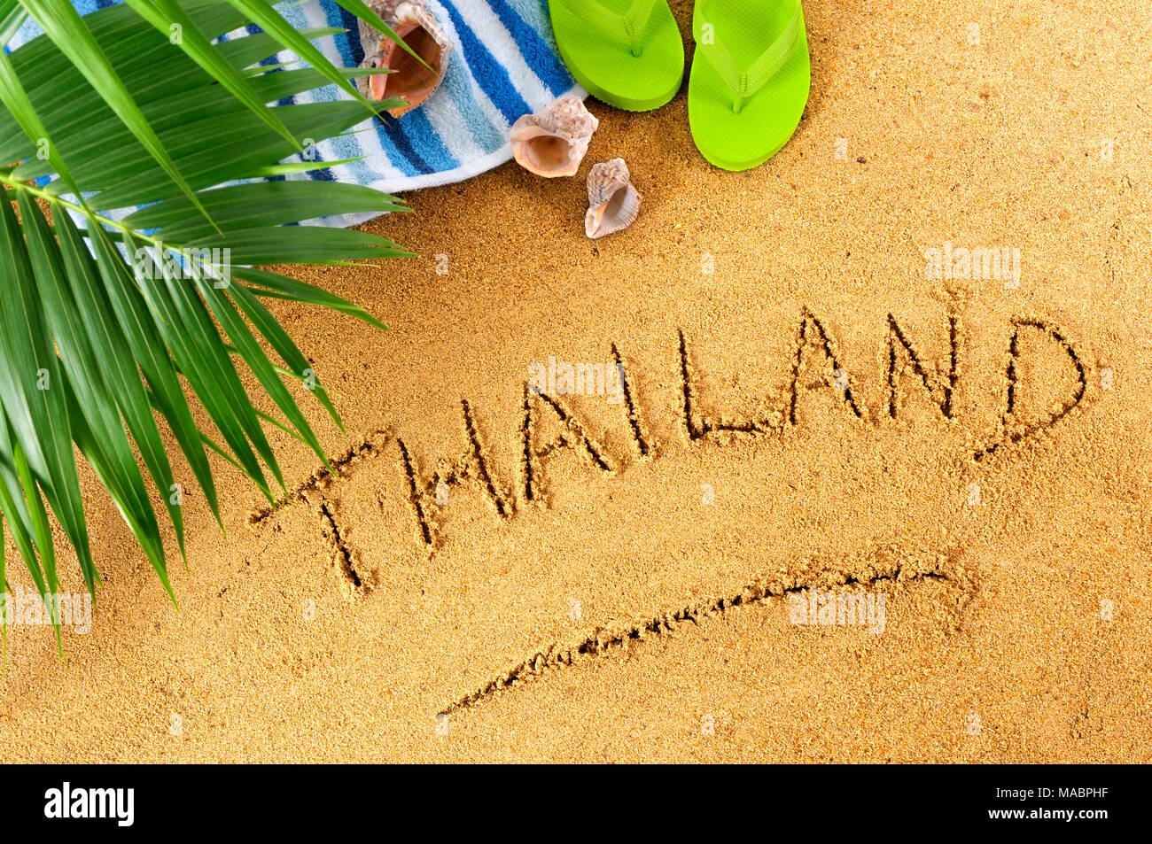 Thailand Strand Hintergrund mit Handtuch, Palmenblättern und Flip Flops. Stockfoto