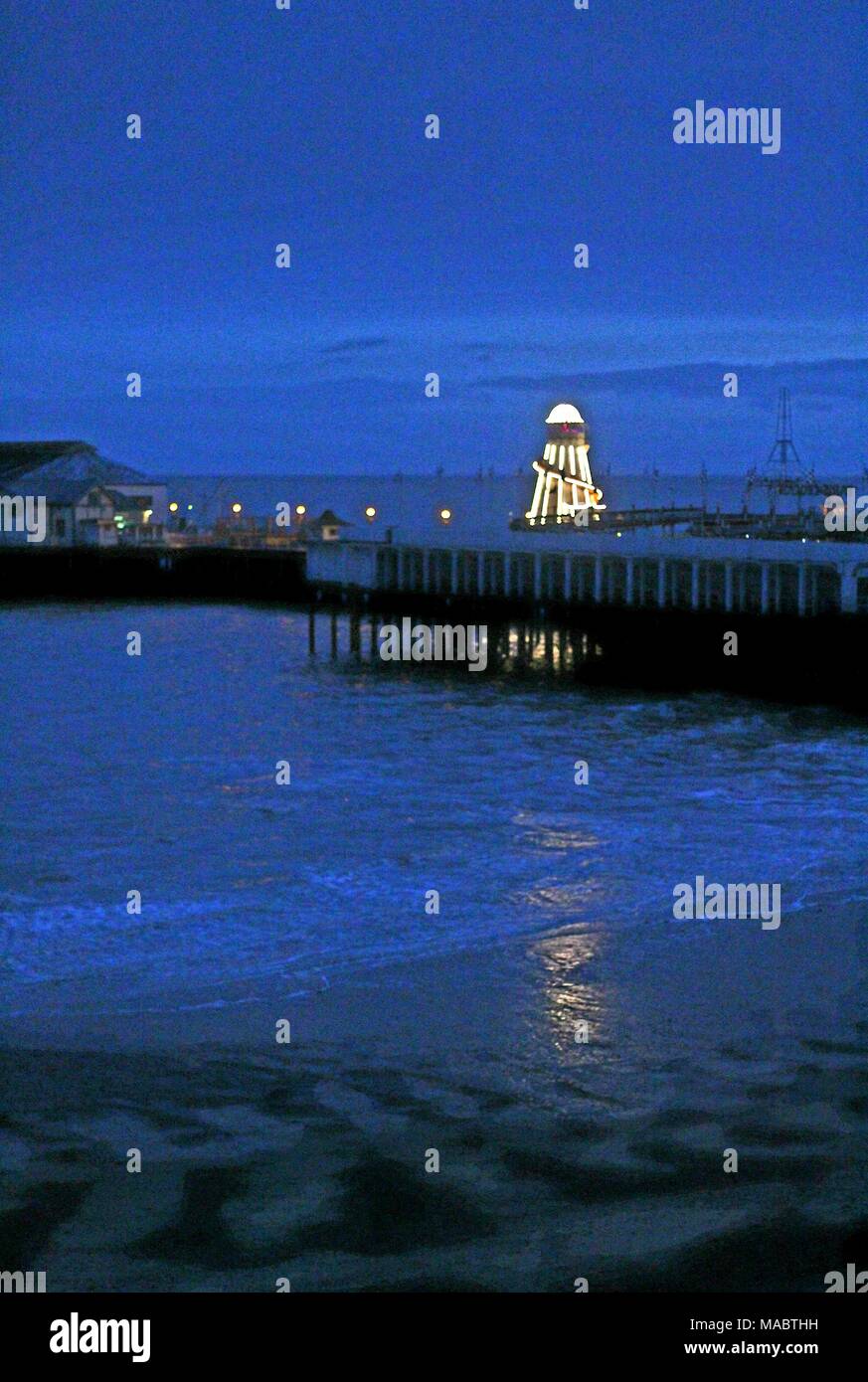 Am Abend fällt bei Clacton Pier - illuminationen von Helter Skelter sind im Meerwasser wider. Platz für Kopieren. Stockfoto