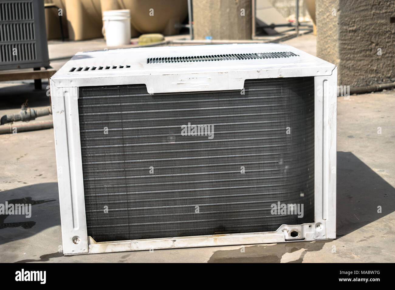 Einen professionellen Elektriker ist die Reinigung der Fenster Klimaanlage auf dem Dach eines Hauses mit einem feuchten Serviette Stockfoto