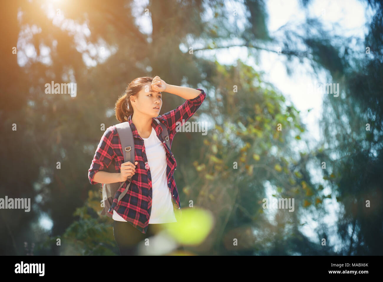 Junge asiatische Frau wischte Schwitzen beim Wandern. Stockfoto