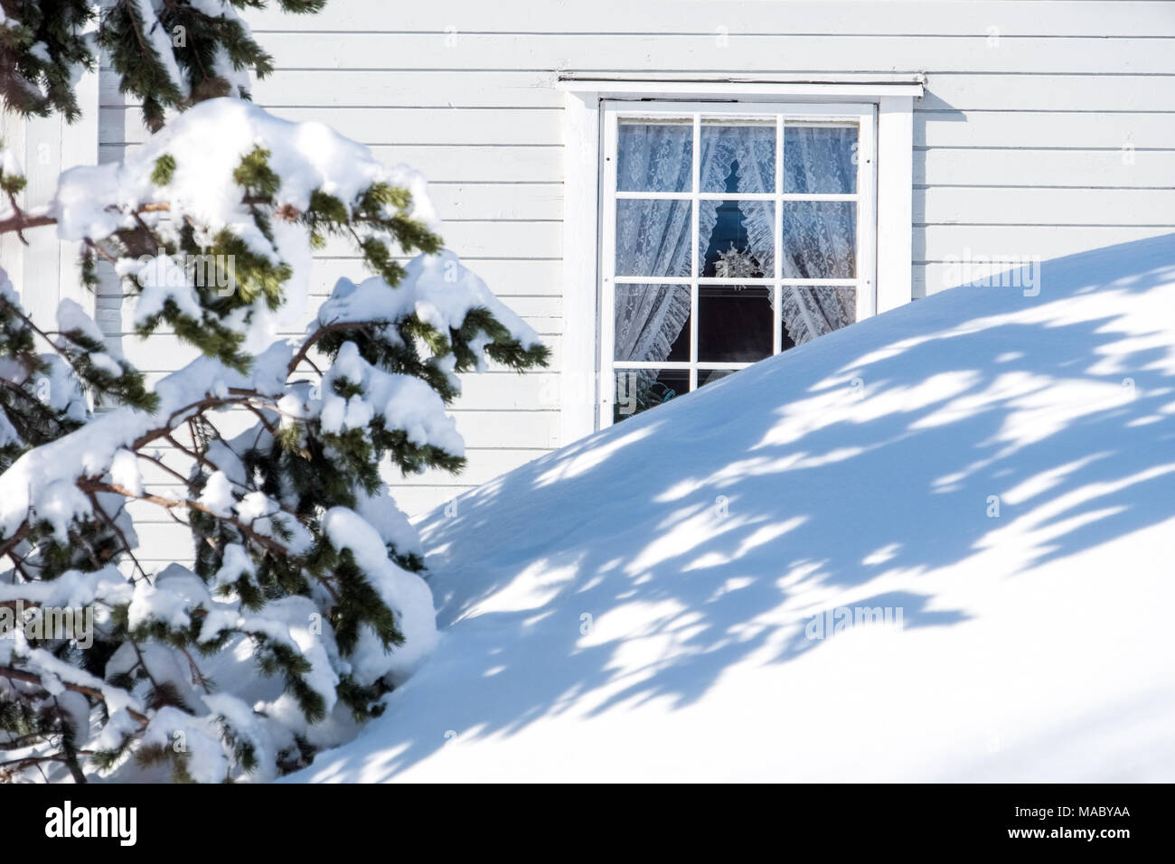 Fenster eines Holzhaus mit einem tiefen Snowdrift außerhalb, Norwegen Stockfoto