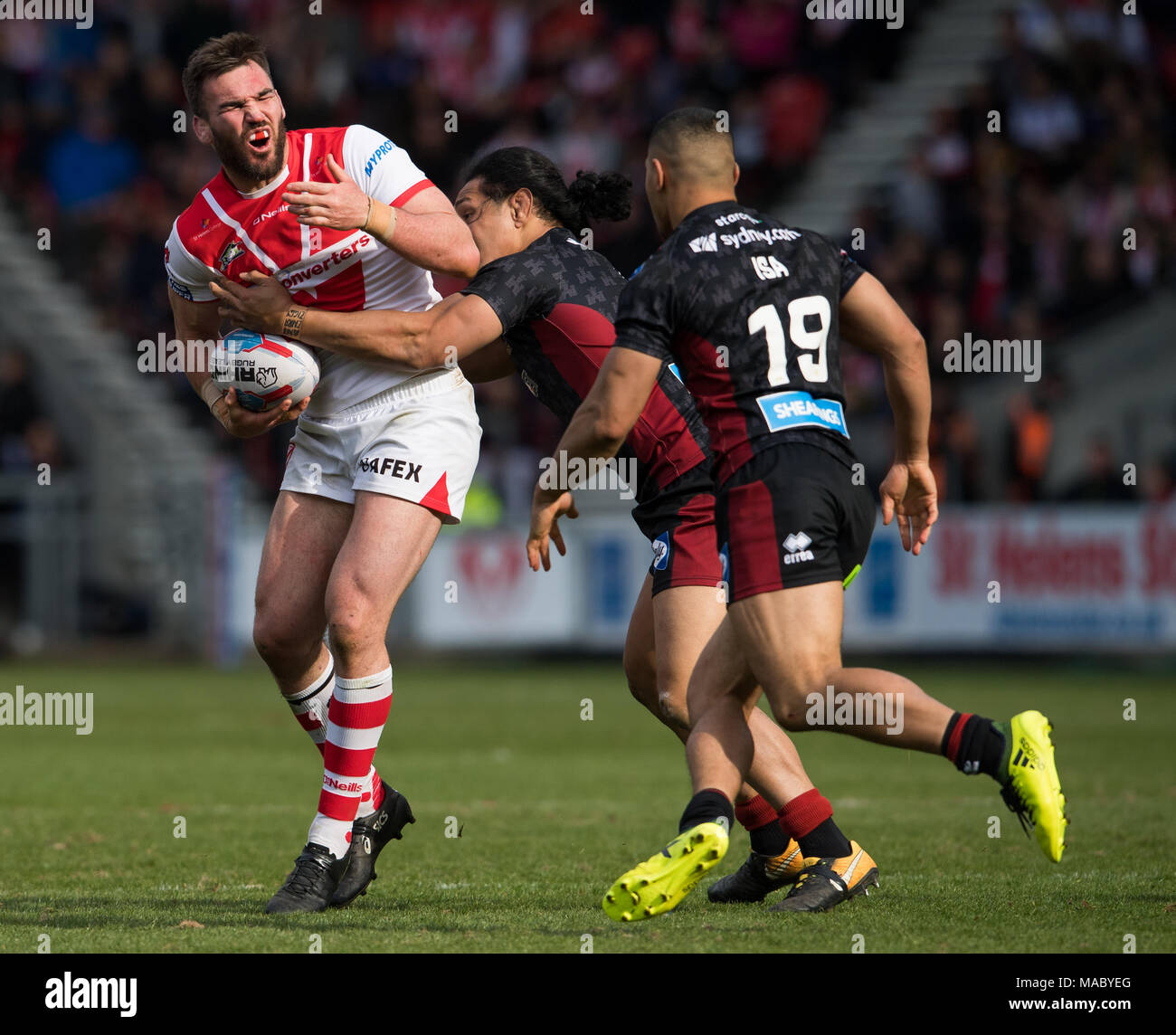 St. Helens Lukas Douglas ist durch Taulima Tautai 30 von Wigan Warriors März 2018, total Gottlosen Stadion, Merseyside, England; Betfred Super angegangen Stockfoto