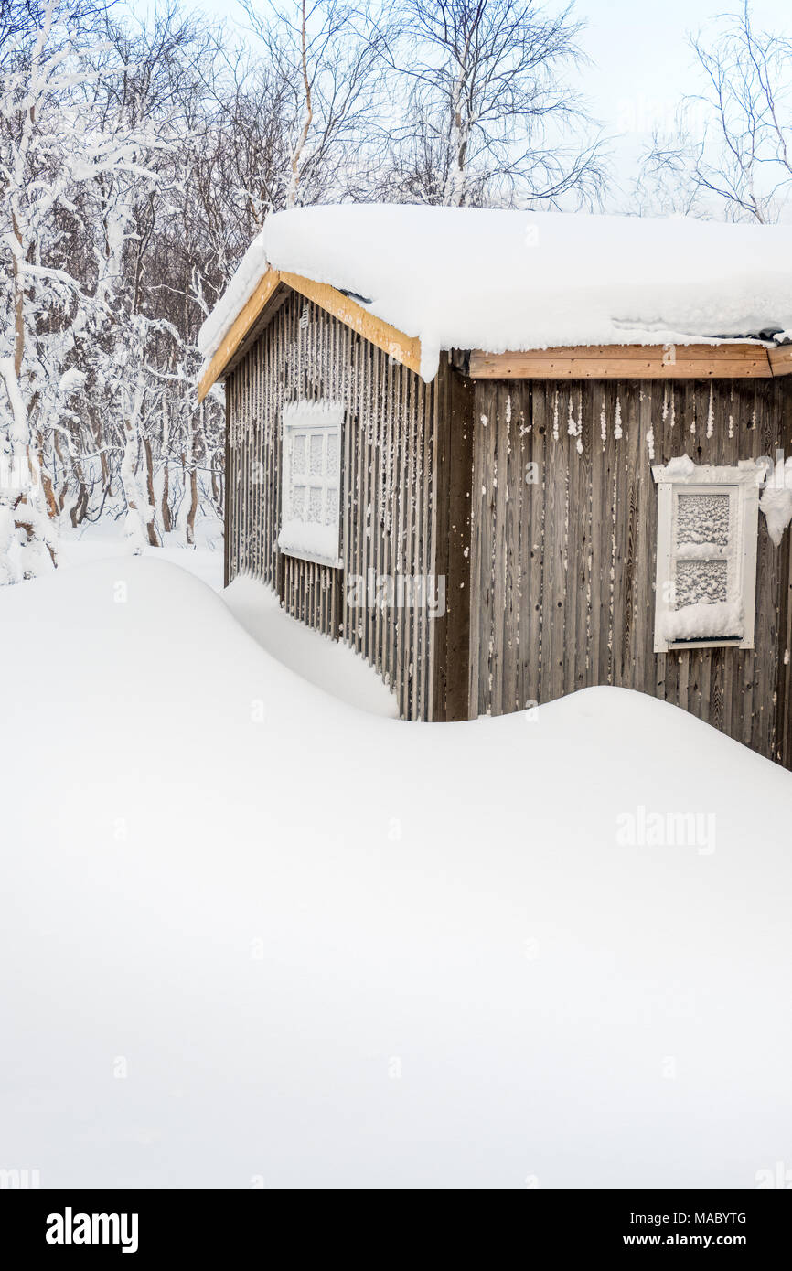 Verschneite Hütte in einem samischen Dorf in Schwedisch Lappland Stockfoto