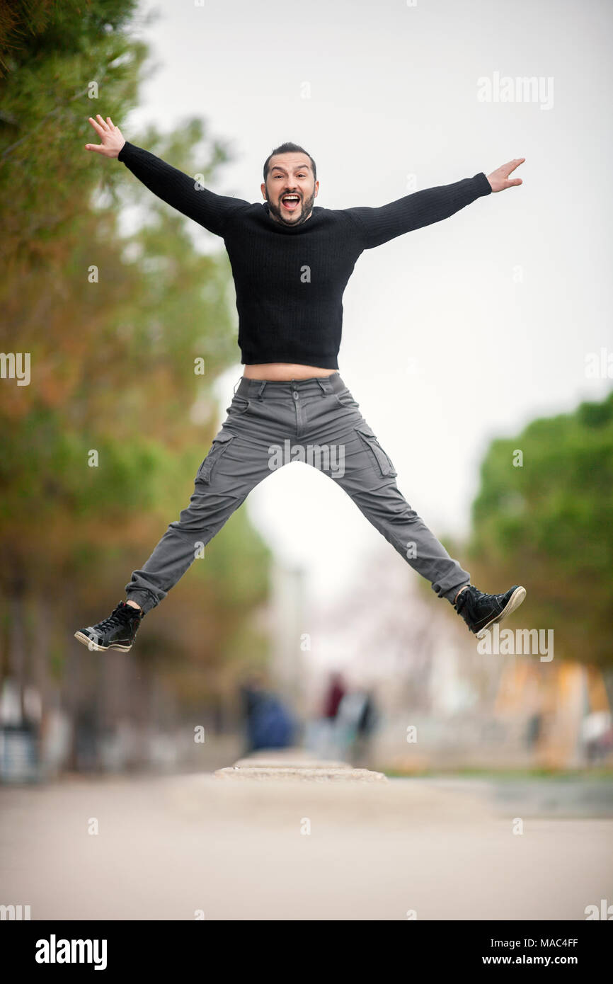 Springen... Aufgeregt, glücklicher Mann springt hoch, legere Kleidung Stockfoto