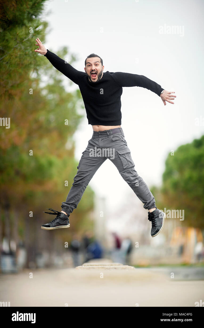 Springen... Aufgeregt, glücklicher Mann springt hoch, legere Kleidung Stockfoto