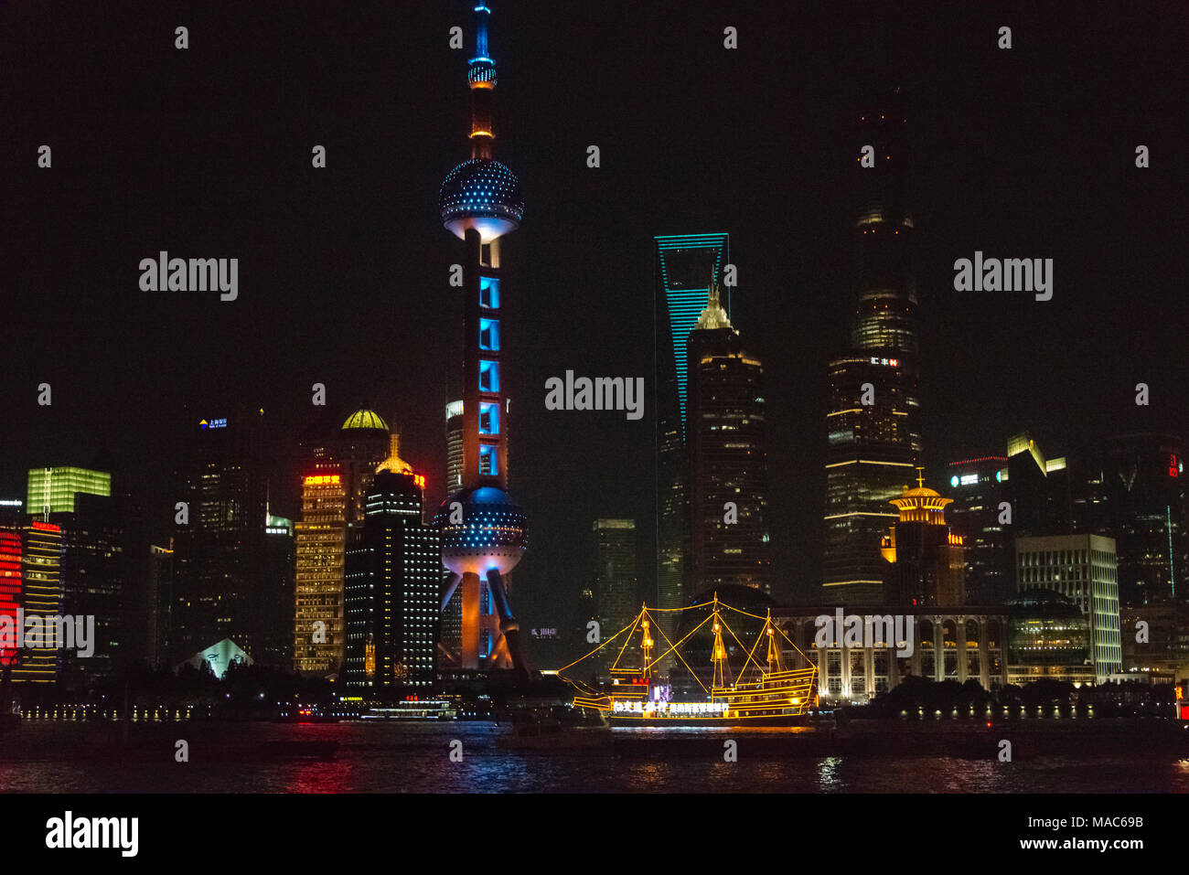 Nacht Blick auf die Skyline von Pudong und Boot auf den Fluss Huangpu, Shanghai, China Stockfoto
