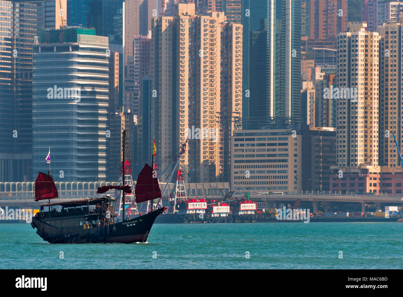 Junk-Boot und Hochhäuser in Victoria Bay, Hong Kong, China Stockfoto