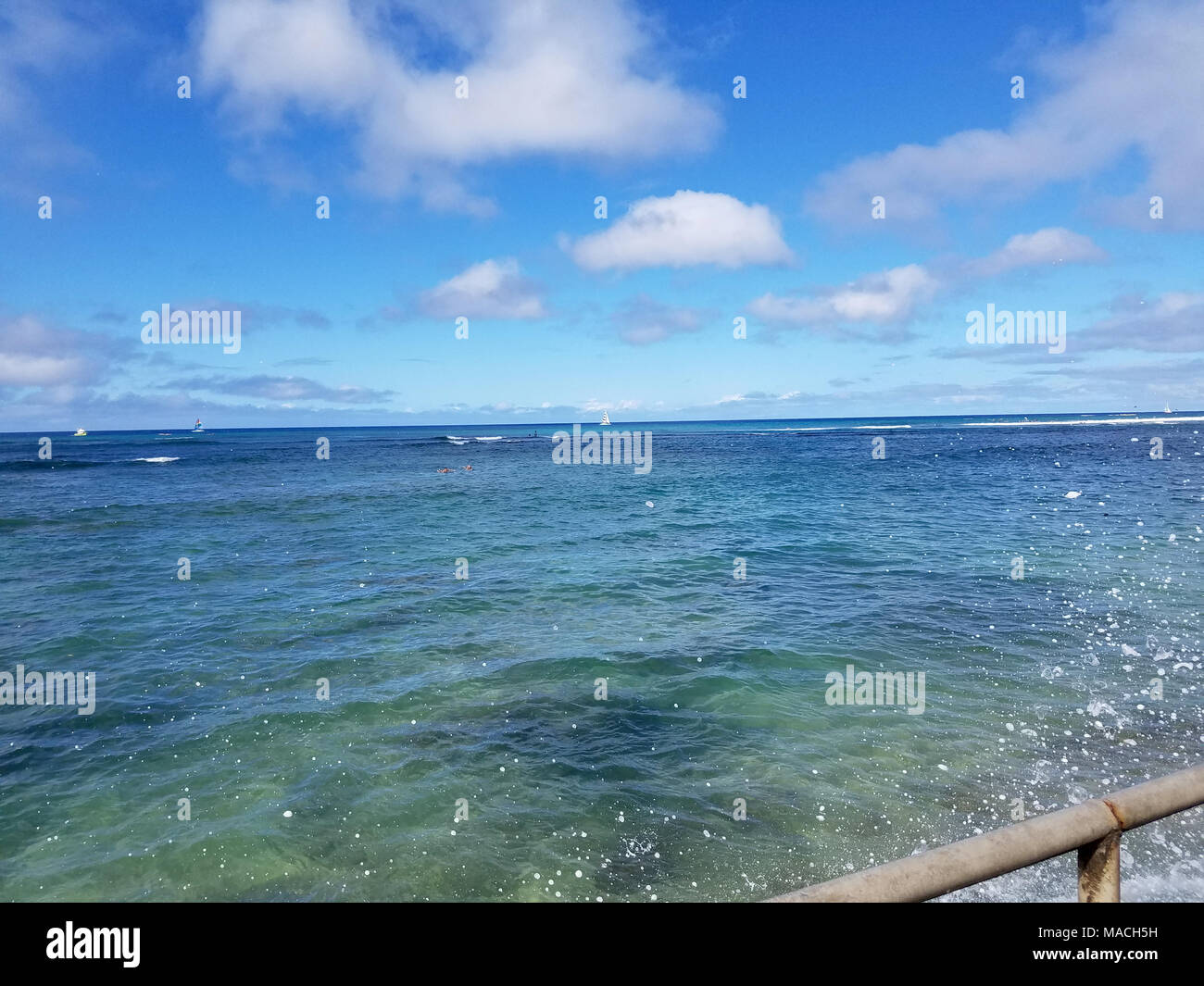 Schattierungen von Türkis blauen Ozean Wassereffekte aus South Shore von Oahu mit Booten auf das Meer und Wasser spritzen in die Luft. Gut für die Hintergrund Textur Stockfoto