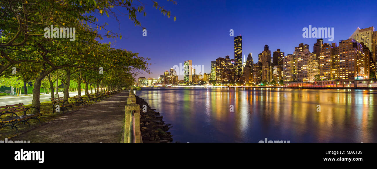 Blick auf Midtown Manhattan Wolkenkratzer und den East River bei Dämmerung von Roosevelt Island Promenade im Sommer. New York City Stockfoto