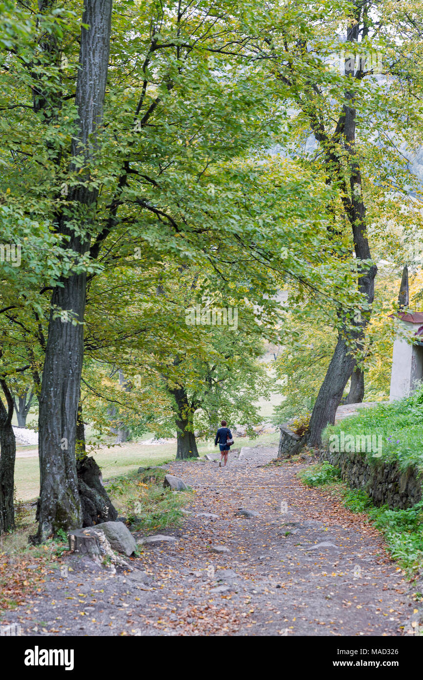 Frau Spaziergang durch alte Stein leere Straße zum Kalvarienberg in Banska Stiavnica, Slowakei. Stockfoto