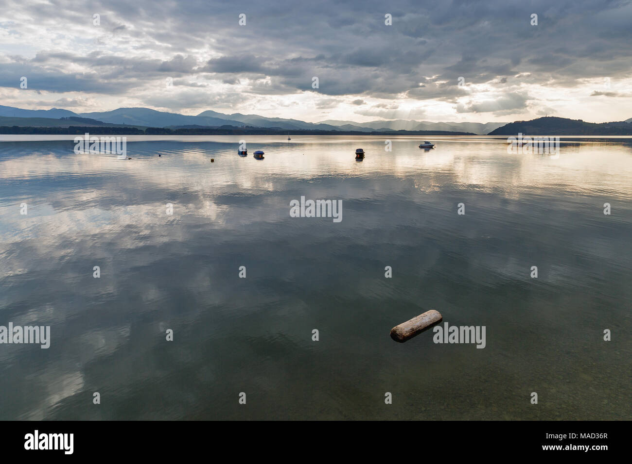 Blick über Wasser Liptovska Mara See mit Ufer von Liptovsky Trnovec ist Dorf und angelegten Boote in der Slowakei. Chocsky Hügel können in der Distanc gesehen werden. Stockfoto