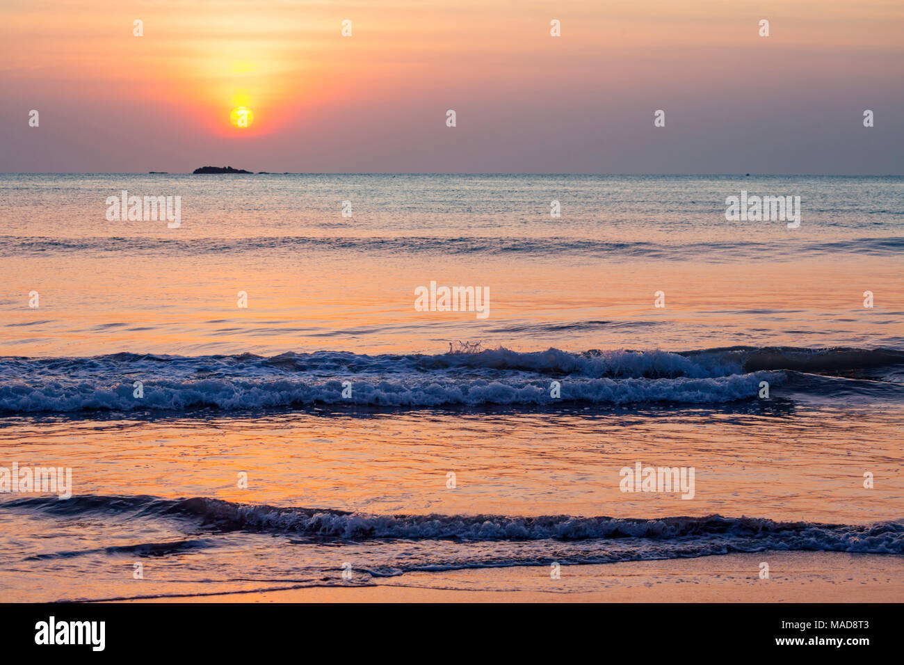 Die Sonne über Pigeon Island National Park aus Nilavelli Strand in Trincomalee, Sri Lanka. Stockfoto