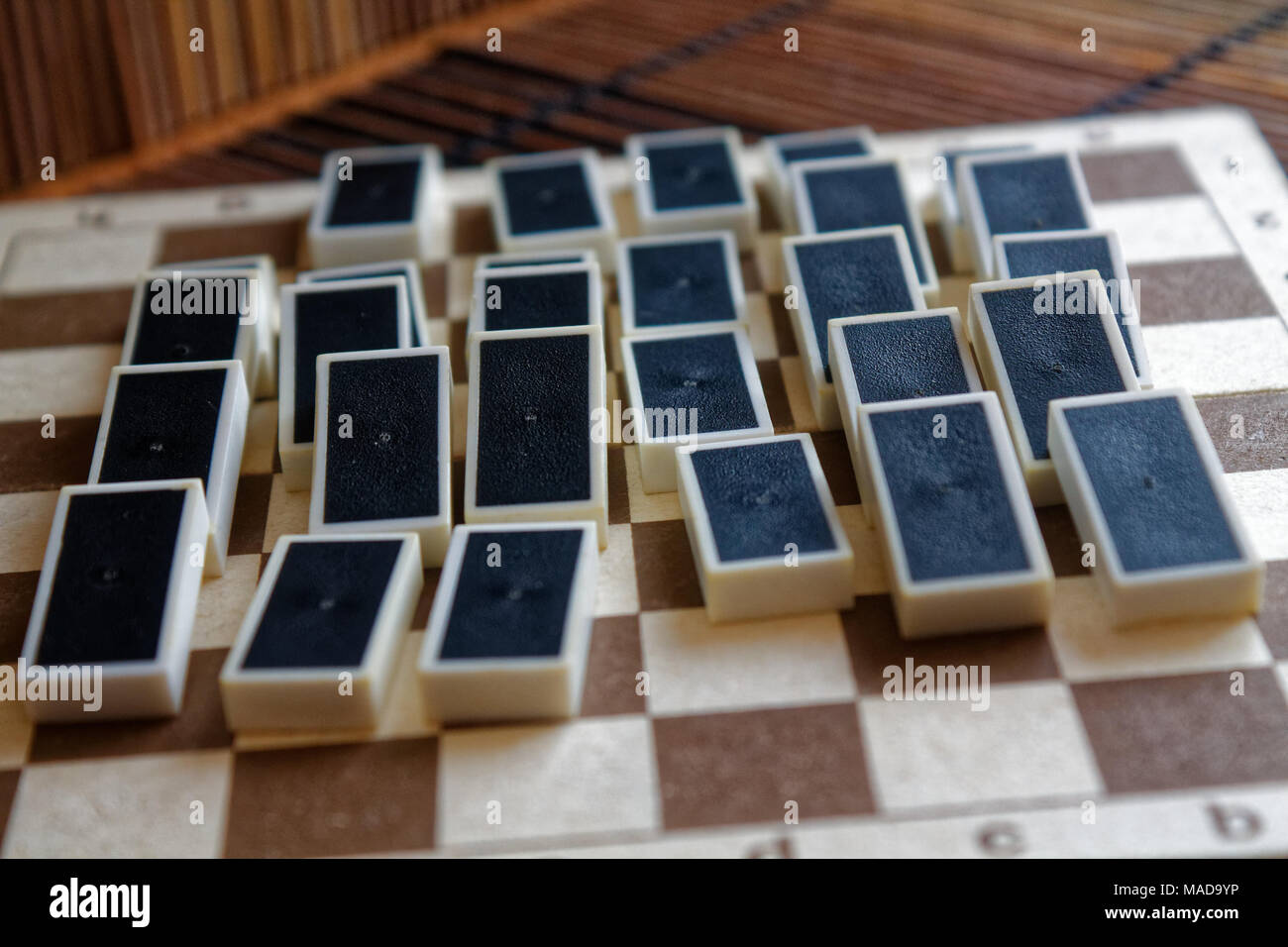Domino Stücke nach Dominoeffekt, Rückseite, auf der Bambus braun Holztisch Hintergrund Stockfoto