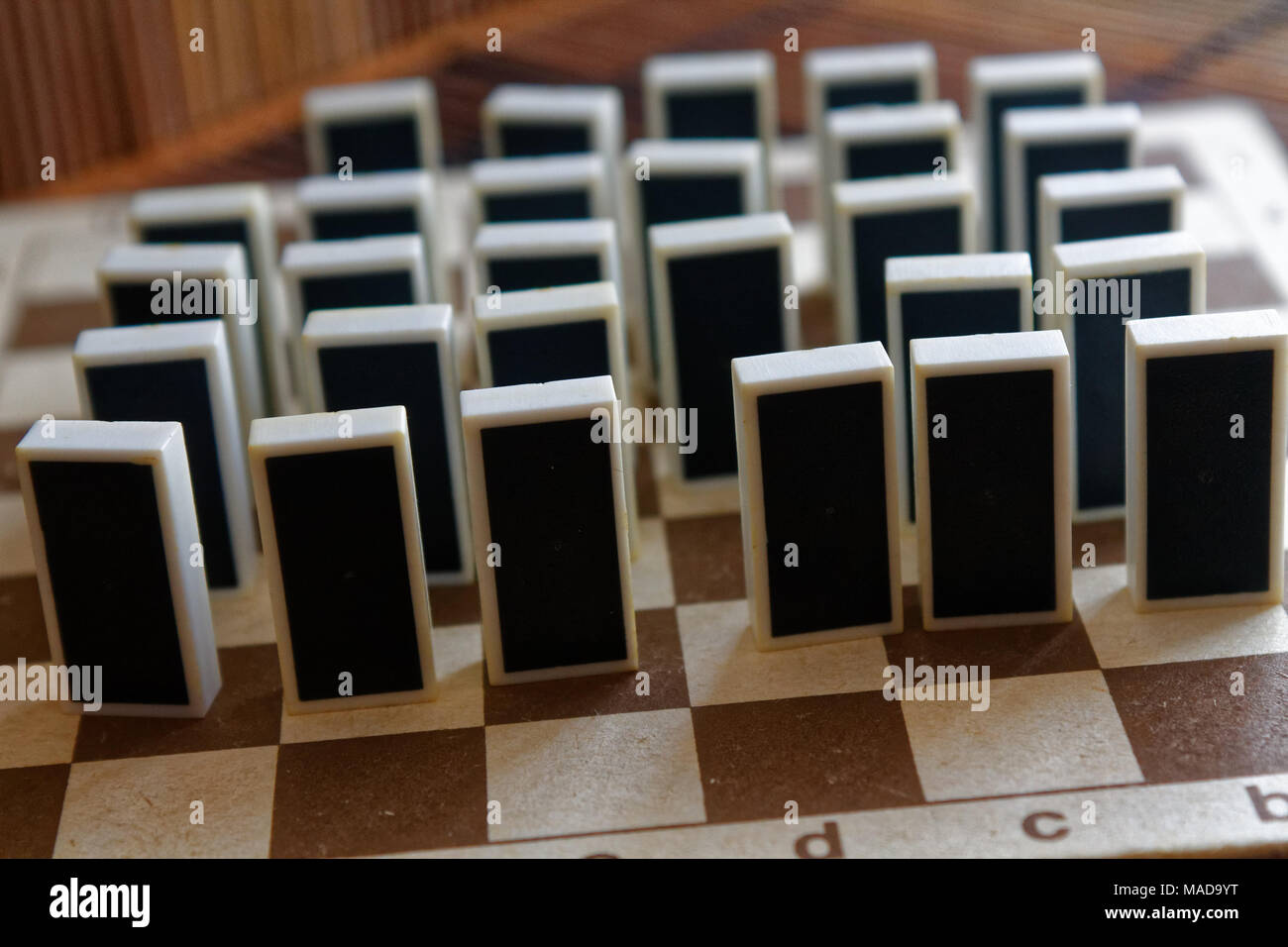 Domino Stücke in einer Reihe, Rückseite auf der Bambus braun Holztisch Hintergrund Stockfoto