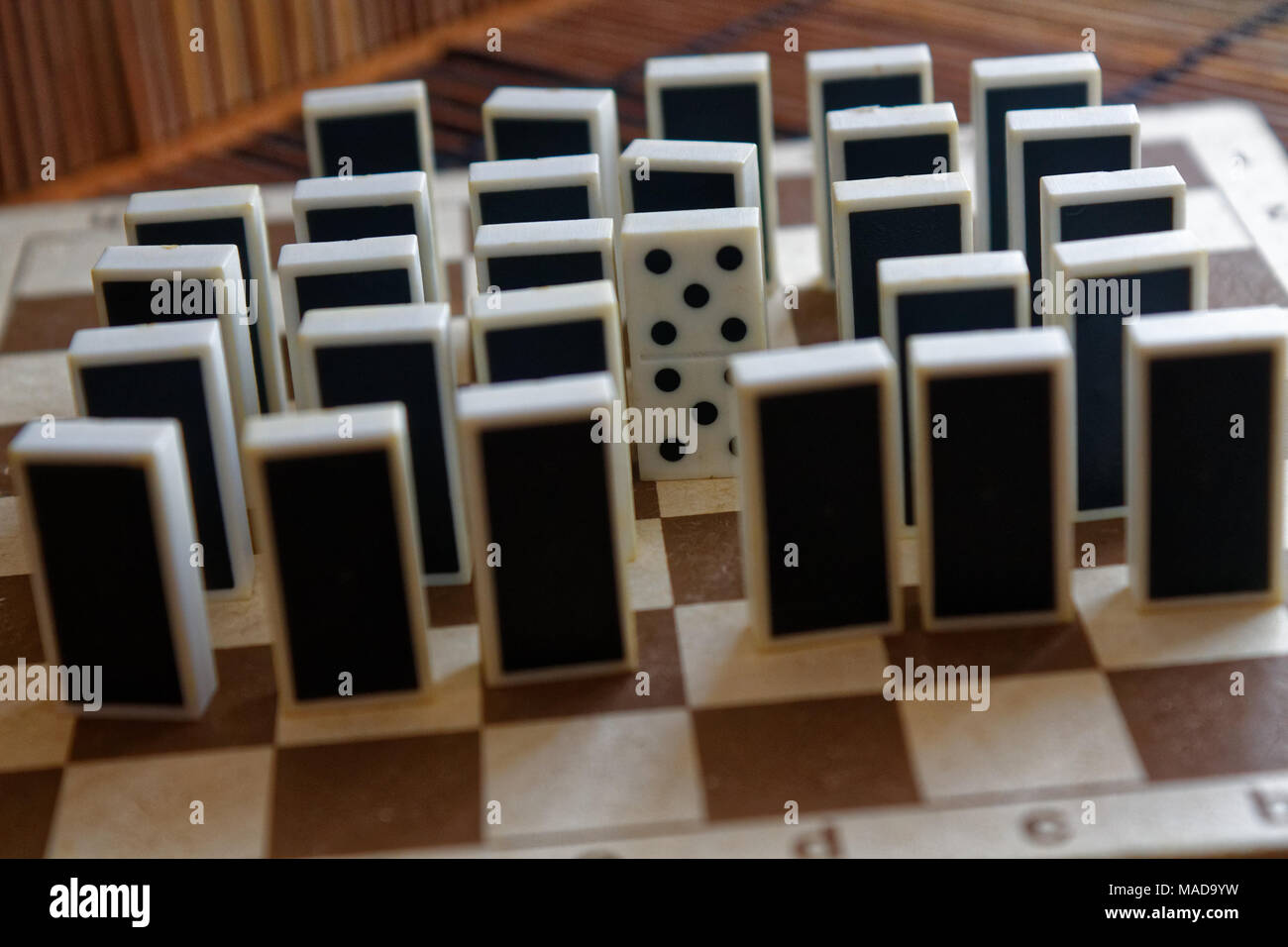 Domino Steine in einer Reihe und einer anderen statnd, Rückseite, auf der Bambus braun Holztisch Hintergrund Stockfoto
