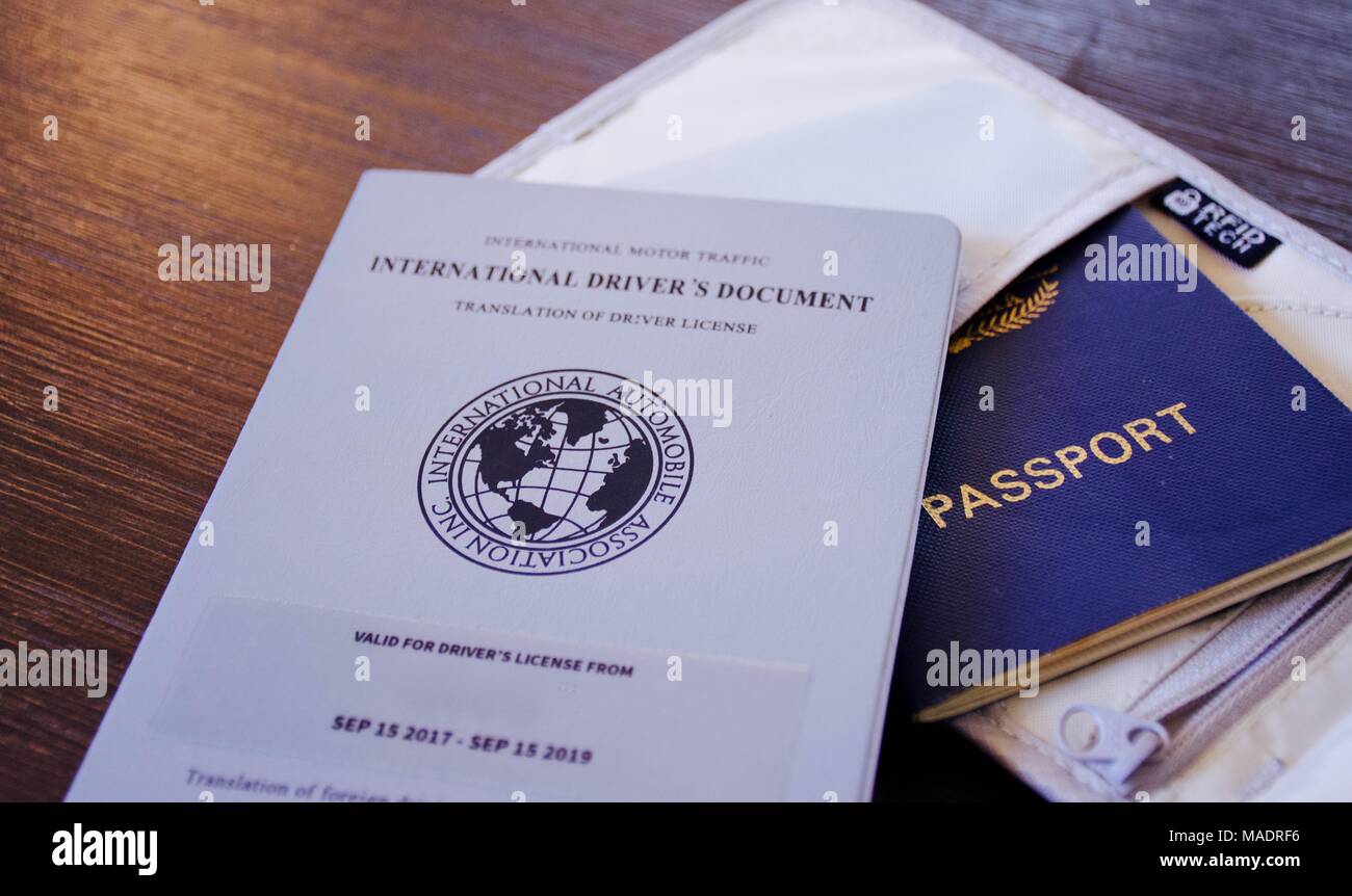 Blauen Pass mit internationalen Treiber in einem RFID-Reisetasche auf einem dunklen Hintergrund Lizenz Stockfoto