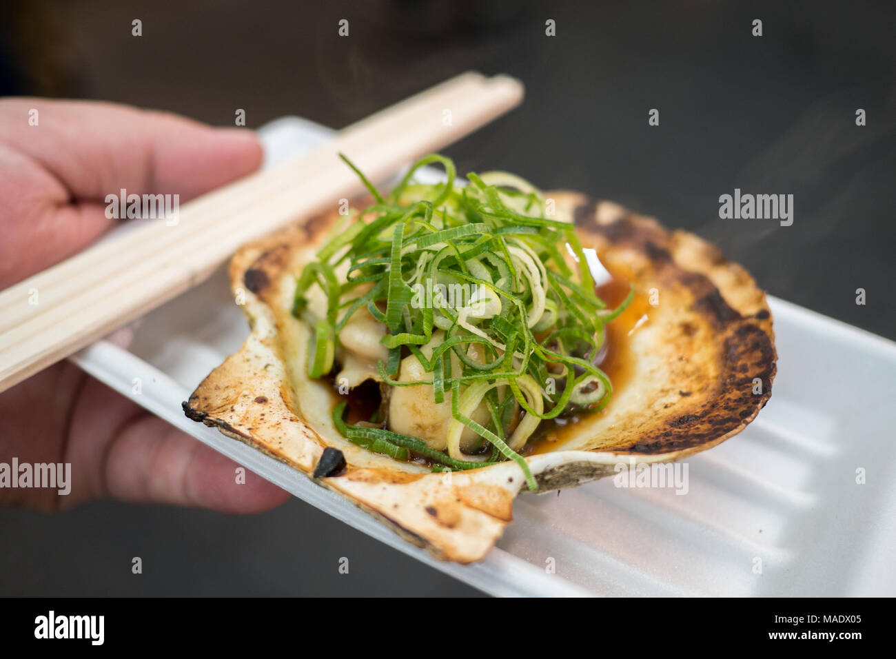 Frisch Jakobsmuschel mit Shell und grüne Zwiebeln an der berühmten: Kuromon Fischmarkt in Osaka gekocht Stockfoto