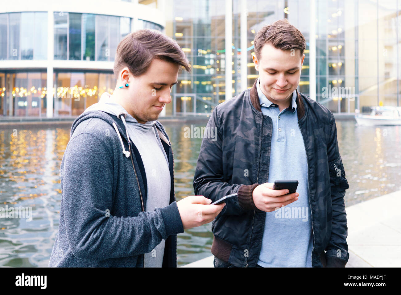 Zwei Handy süchtig männliche Jugendliche gemeinsam am Smartphone suchen Stockfoto