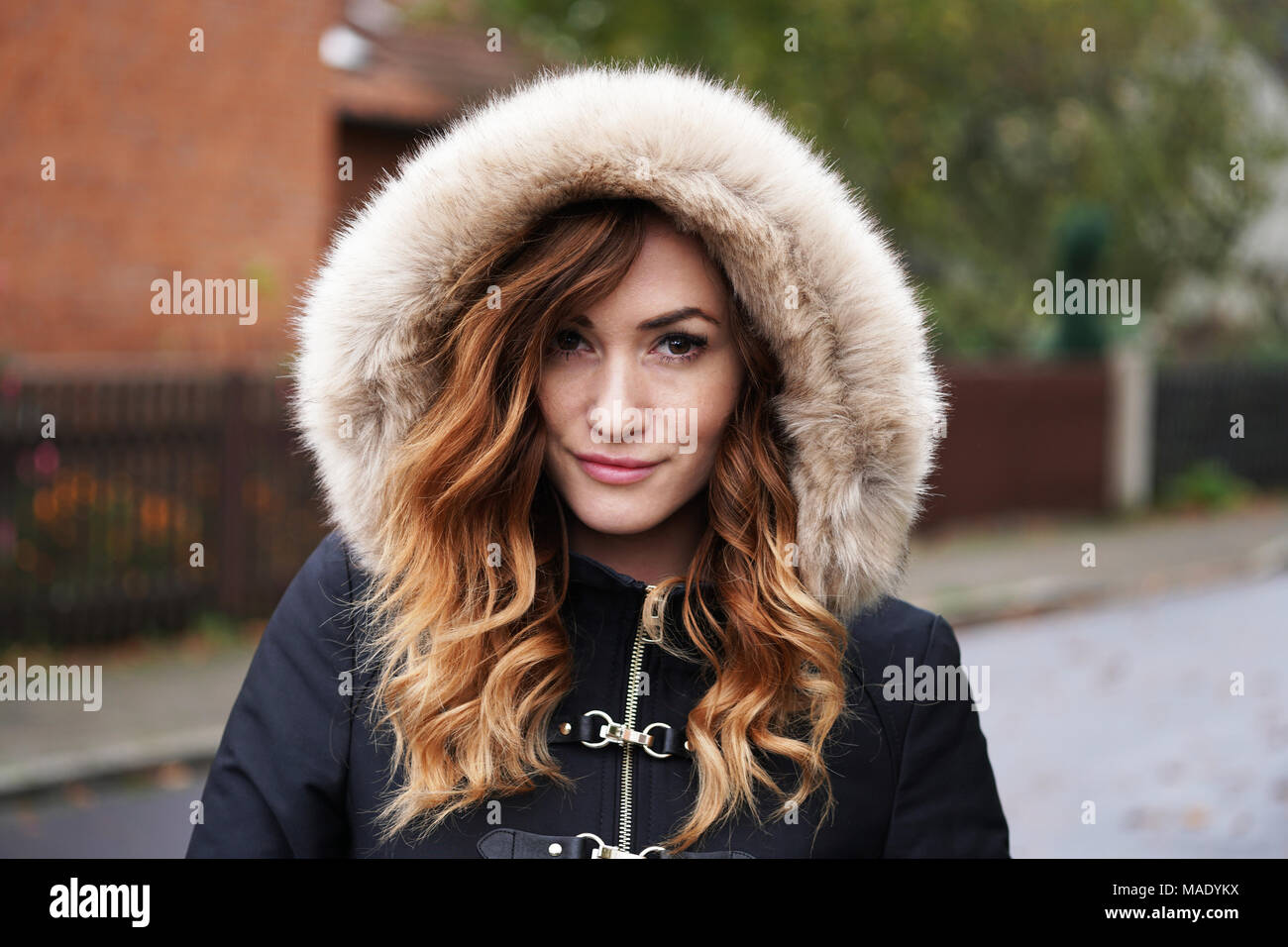 Junge Frau tragen Winter Mantel mit Kunstfell Haube im Freien Stockfoto