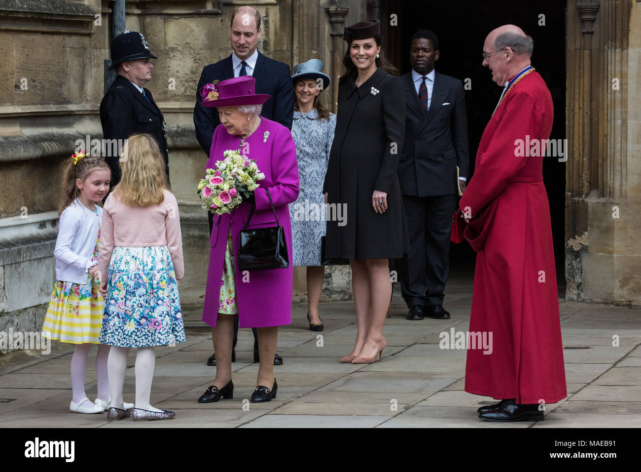 Windsor, Großbritannien. Der 1. April 2018. Madeleine Carleston und Amelia  Vivian, beide im Alter von 6, geben die traditionellen posies von Blumen an  die Königin, als sie den Ostersonntag Service in der