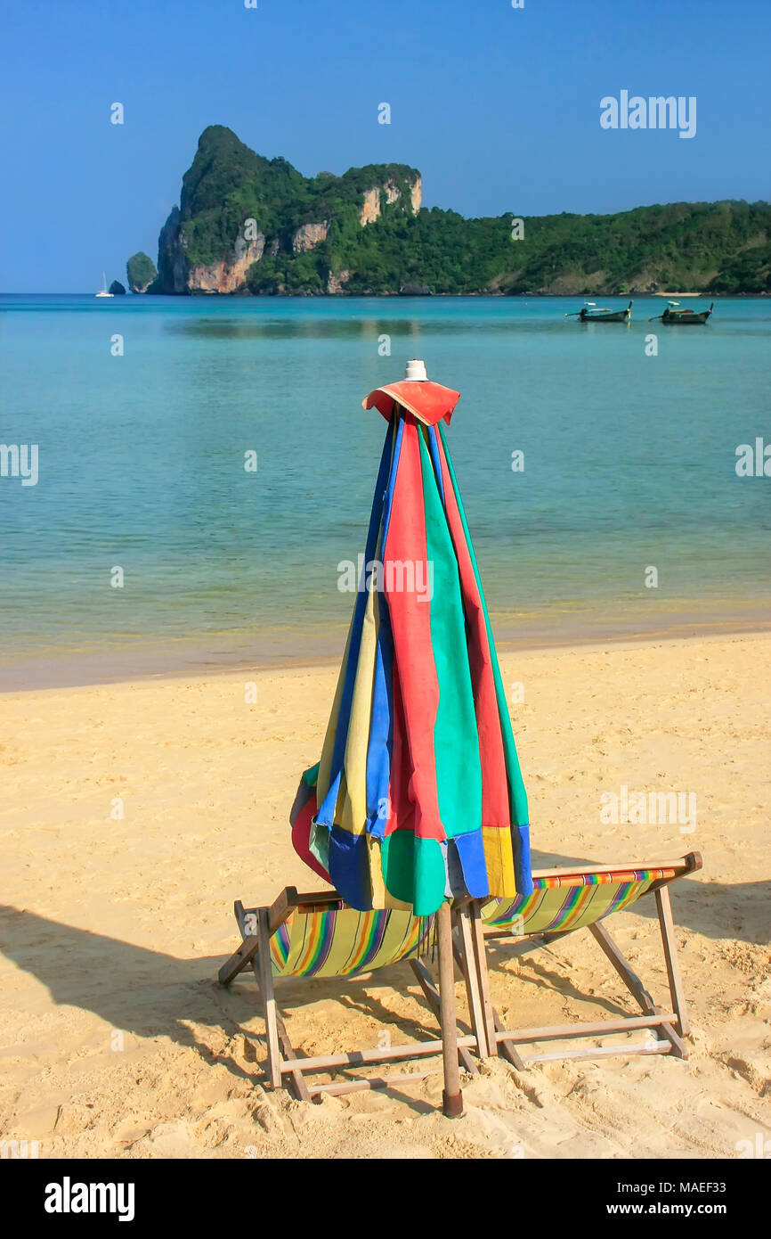 Umиrella und Liegestühlen bei Ao Loh Dalum Strand auf Koh Phi Phi Don Island, Krabi Thailand. Koh Phi Phi Don ist ein Teil der Marine National Park. Stockfoto