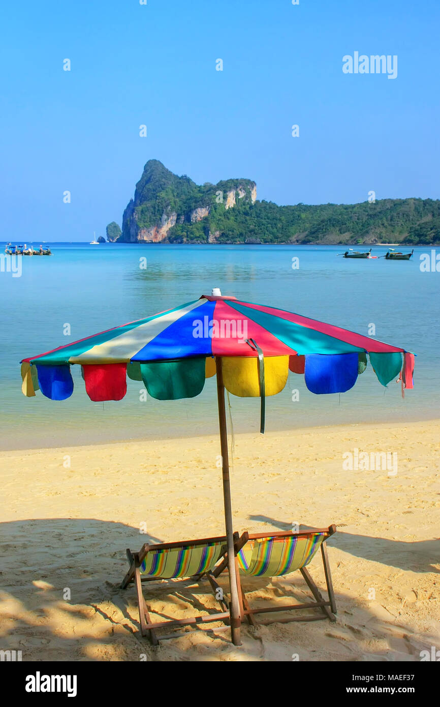 Umиrella und Liegestühlen bei Ao Loh Dalum Strand auf Koh Phi Phi Don Island, Krabi Thailand. Koh Phi Phi Don ist ein Teil der Marine National Park. Stockfoto