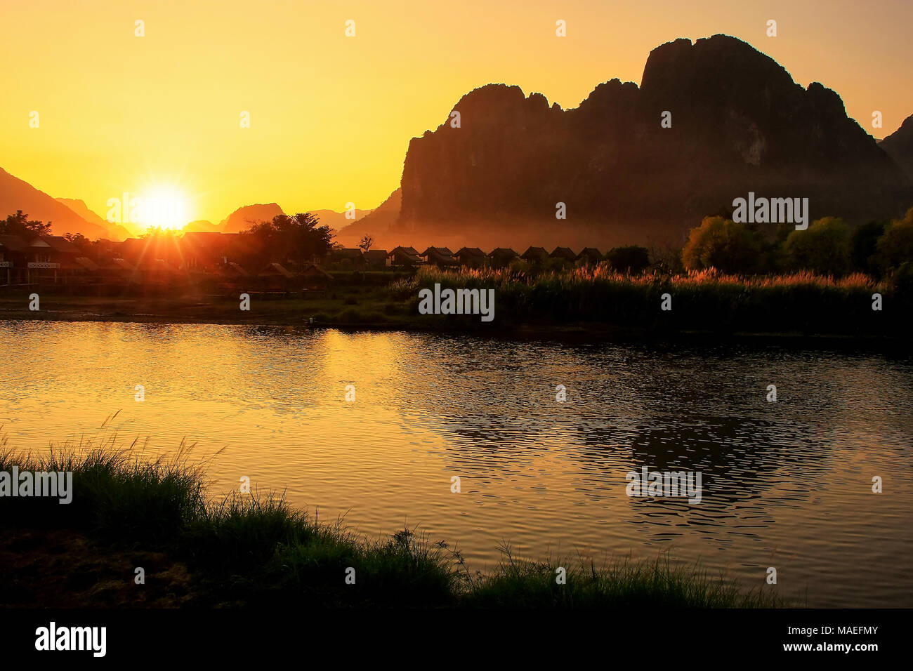 Sonnenuntergang über Nam Song River mit Silhouette Felsformationen in Vang Vieng, Laos. Vang Vieng ist ein beliebtes Reiseziel für Abenteuer-Tourismus in einer limest Stockfoto