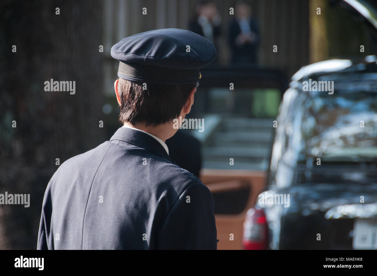 Japanische Tokio Taxifahrer zu seinem schwarzen Taxi links Stockfoto