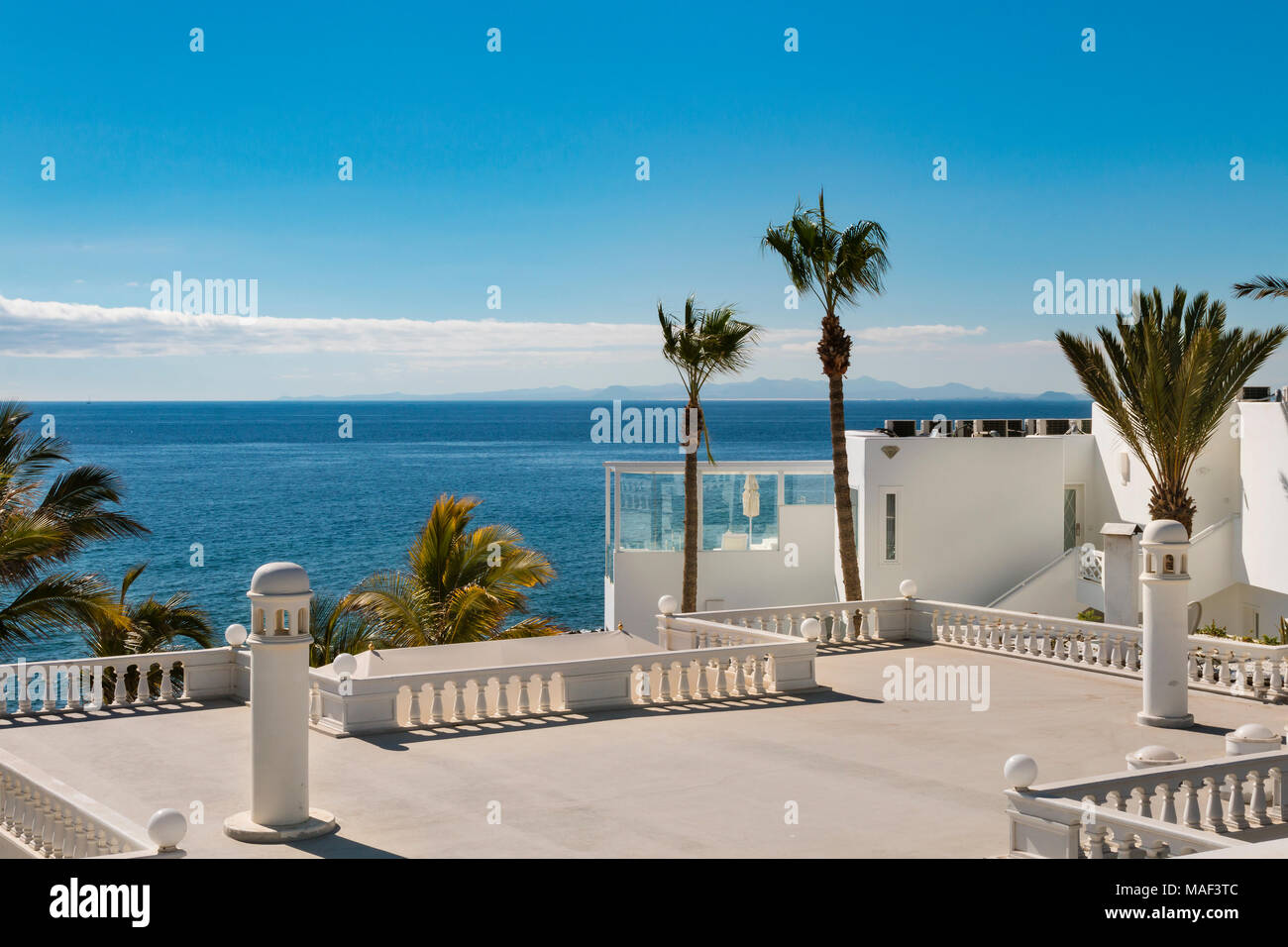 Blick über die Dächer der Häuser mit Palmen in Puerto del Carmen auf Lanzarote, Spanien zum Meer. Stockfoto