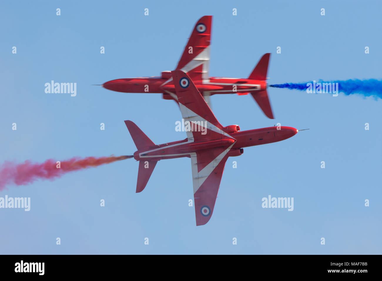 RAF Red Arrows-Flugzeuge, die in unmittelbarer Nähe aneinander vorbeifliegen Stockfoto