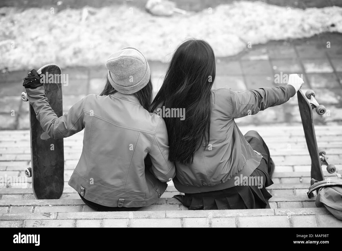 Ein junger Hippie girl reitet ein Skateboard. Mädchen Freundinnen für einen Spaziergang in der Stadt mit einem Skateboard. Frühling Sport auf der Straße mit einem Skateboard. Stockfoto