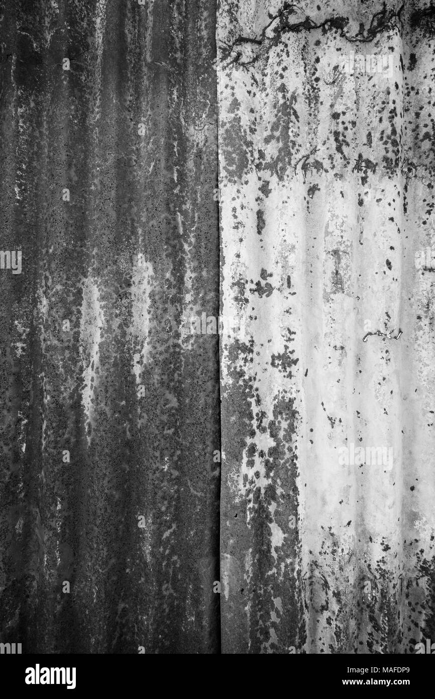 Nahaufnahme einer rostigen und Wellblech metall Baustelle wand Textur Hintergrund mit Vignette in Schwarz und Weiß. Stockfoto