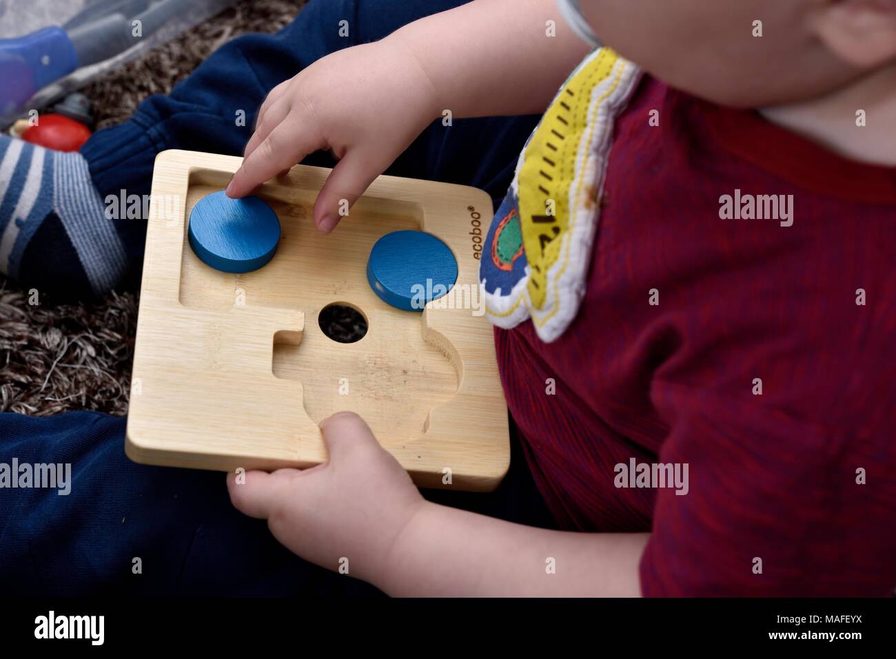 Kleinkind Junge spielt mit Holz Puzzle Stockfoto