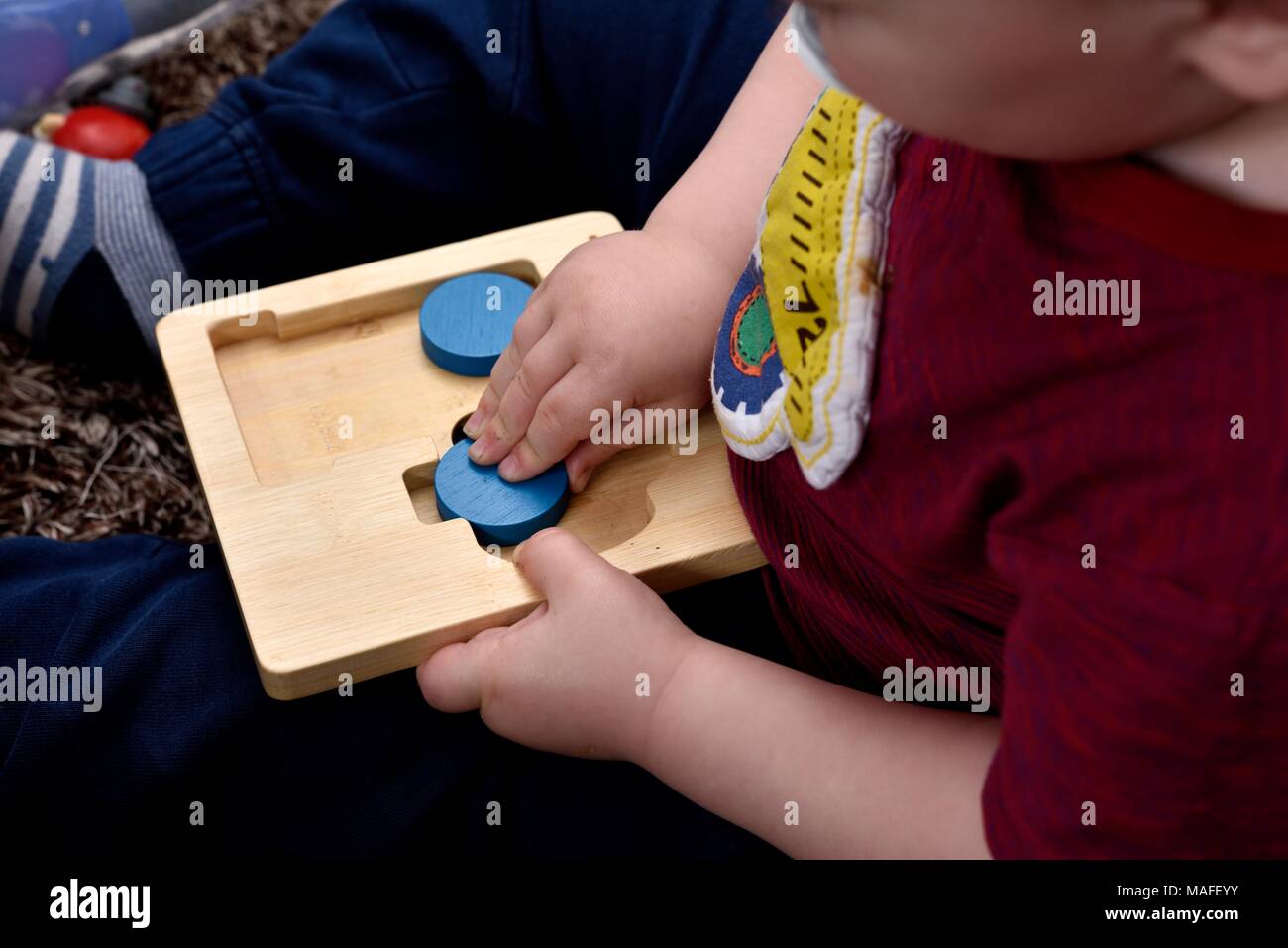 Kleinkind Junge spielt mit Holz Puzzle Stockfoto