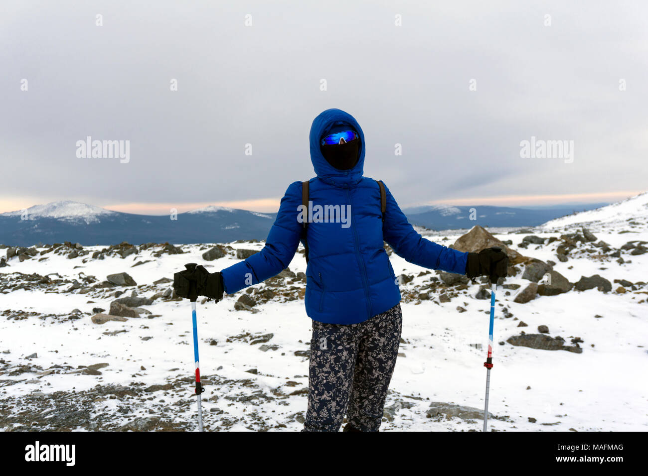 Girl Traveler in warme Kleidung, winddicht Maske und winddicht Gläser im Winter Berge Stockfoto