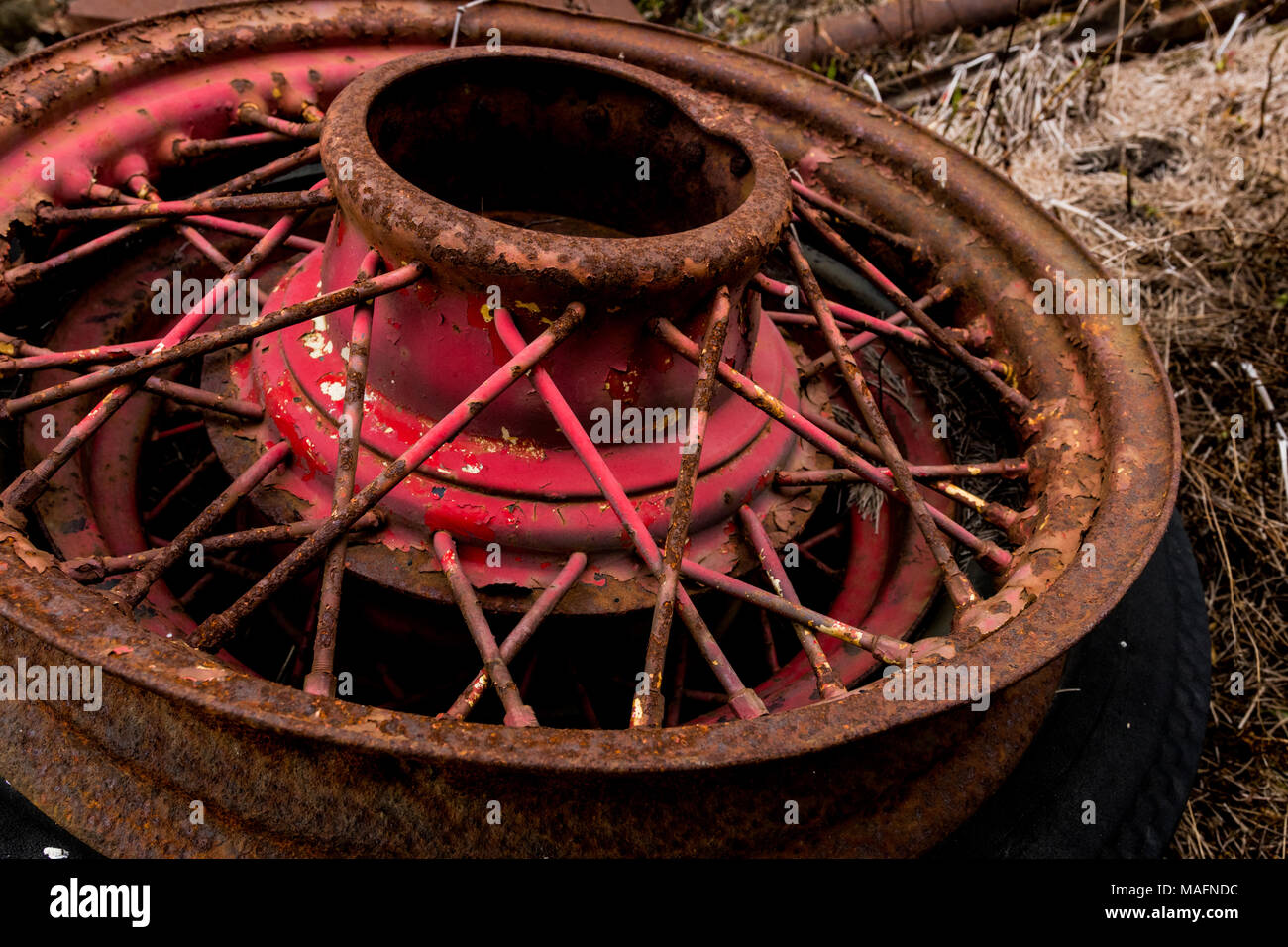 Vintage antik automotive Kabel Speichen und Nabe mit roten abblätternde Farbe und Rost und Oxidation Stockfoto