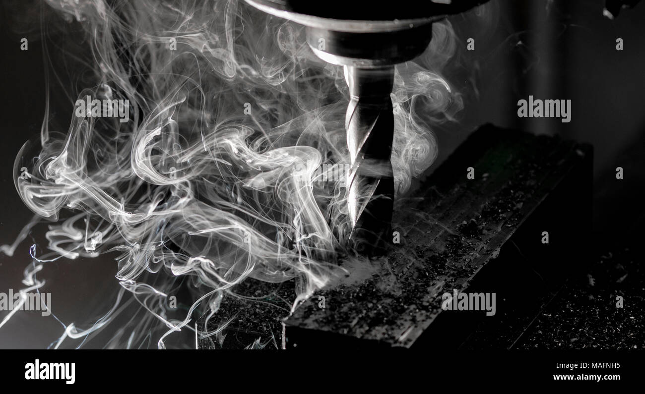 Bridgeport CNC-Fräser schlichten ein Stack aus Stahlblech mit metallspäne Chips und schwerer Rauch Hinterkante Stockfoto
