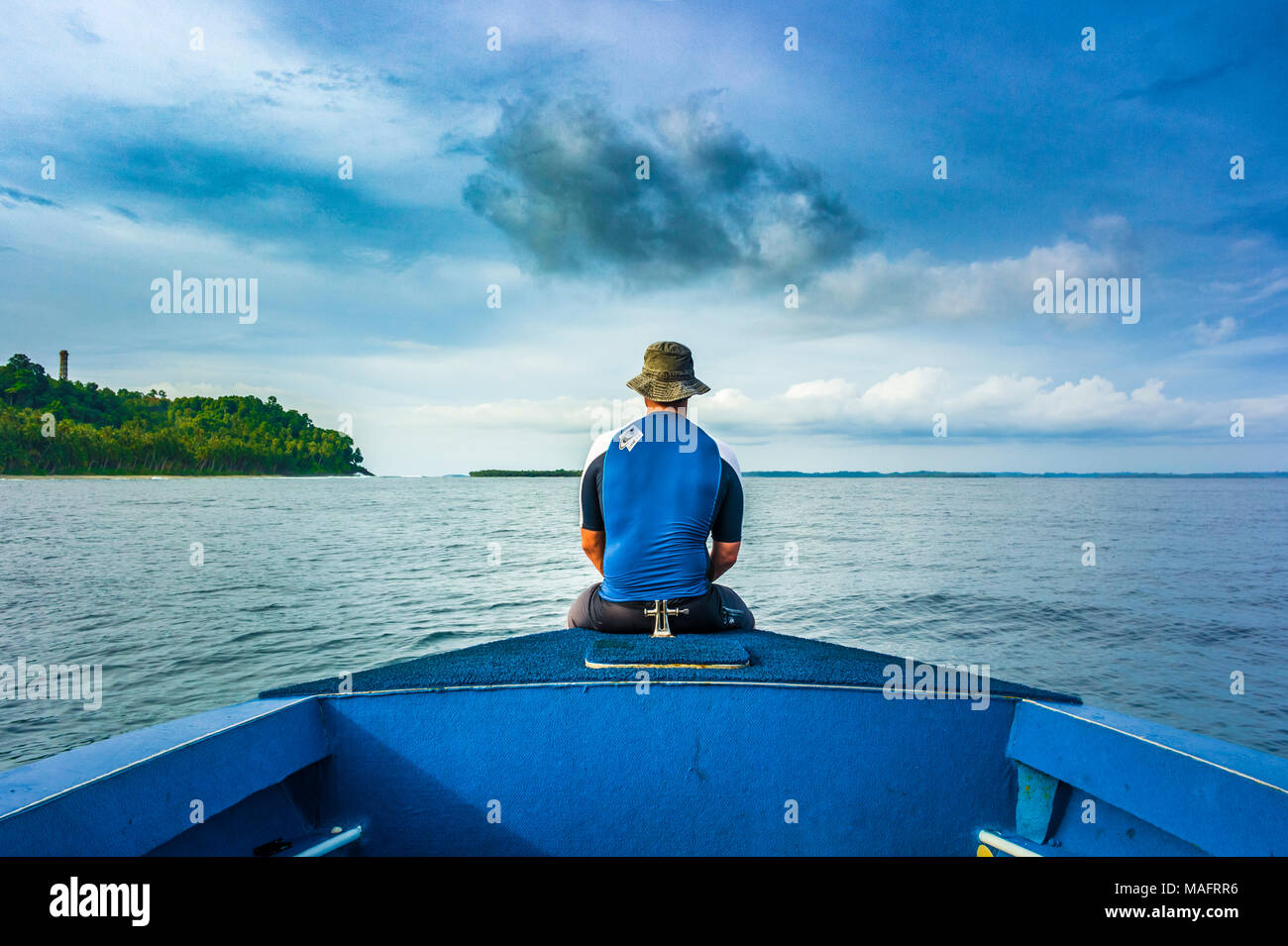 Mann sitzt im Bug des Bootes Stockfoto