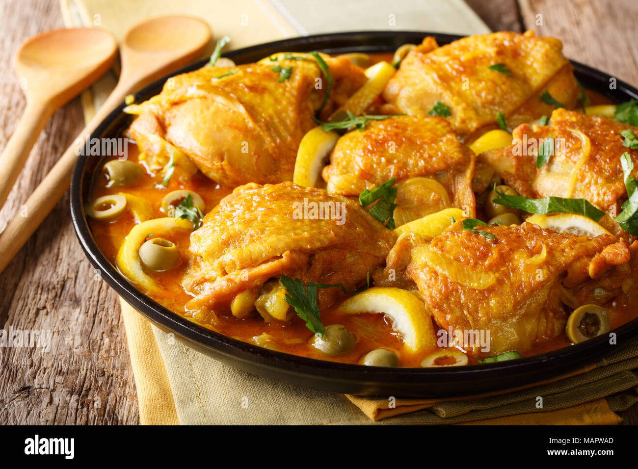 Goldene Huhn mit gesalzenen Zitronen, Zwiebeln, Gewürze und grüne Oliven close-up auf einem Teller. Horizontale Stockfoto