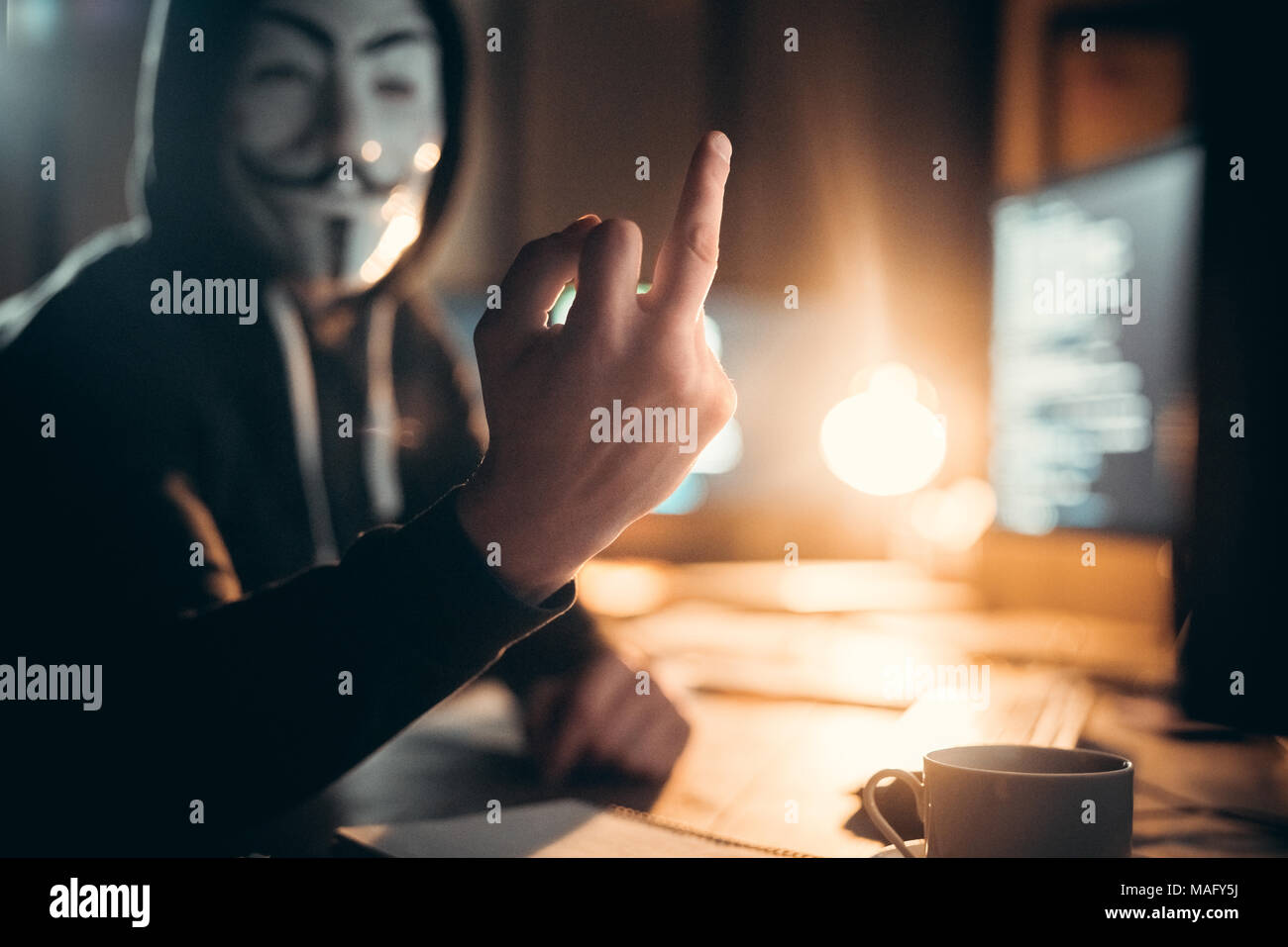 Hacker in der Maske angezeigt fuck Zeichen an der Kamera. Innen-, Studio gedreht. Hackerangriffe, Viren, net-Konzept Stockfoto