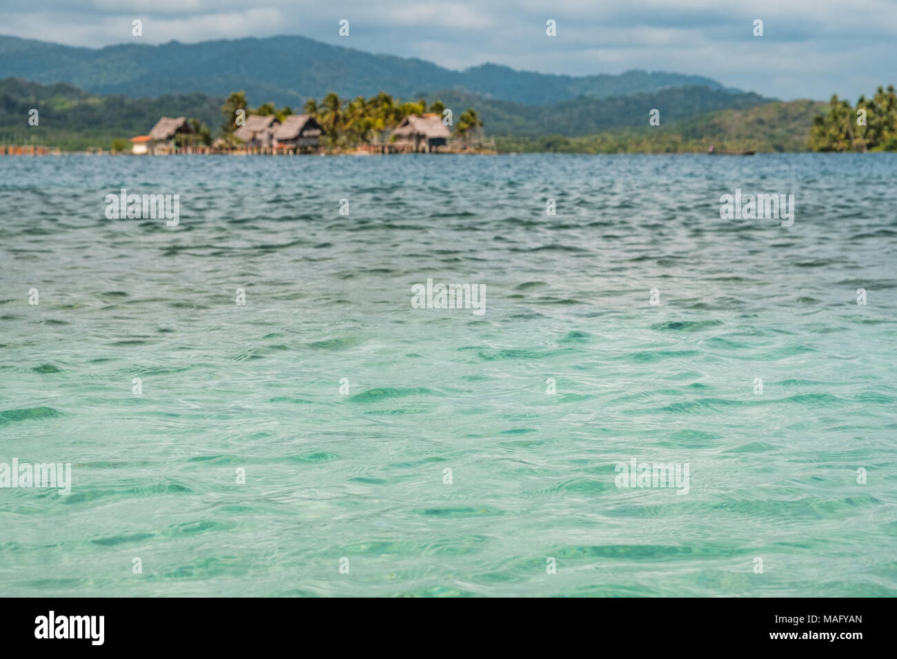 Ozean Wasser Textur closeup mit Insel und Holzhäuser Hintergrund - Guna Yala, San Blas Inseln Stockfoto